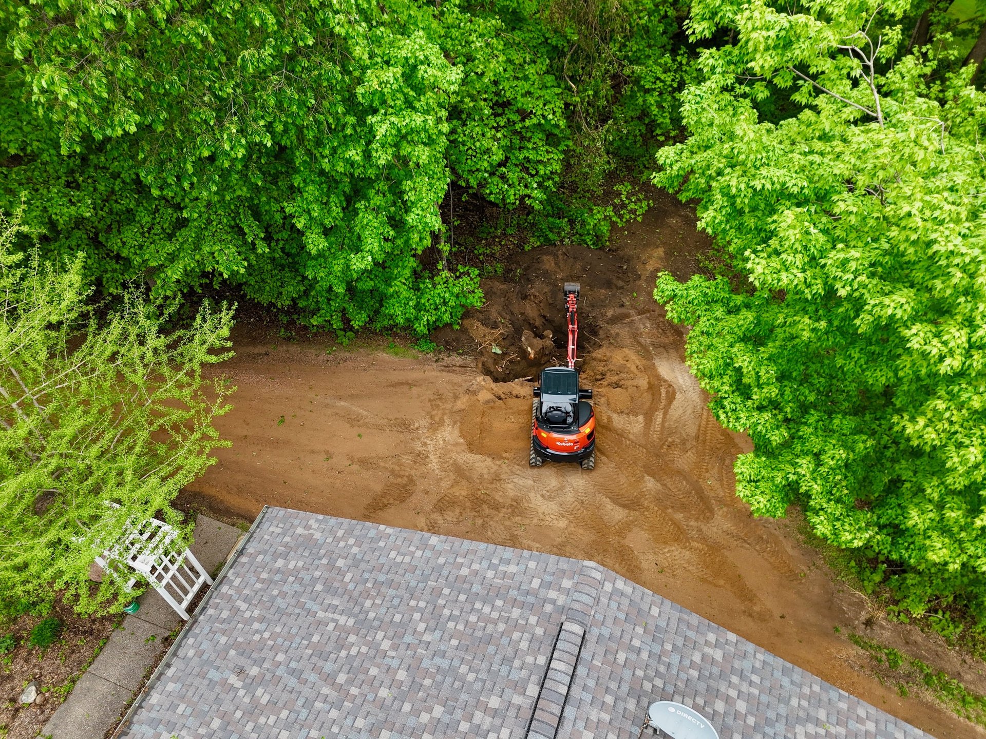 Kubota excavator digging dirt at residential home in central mn