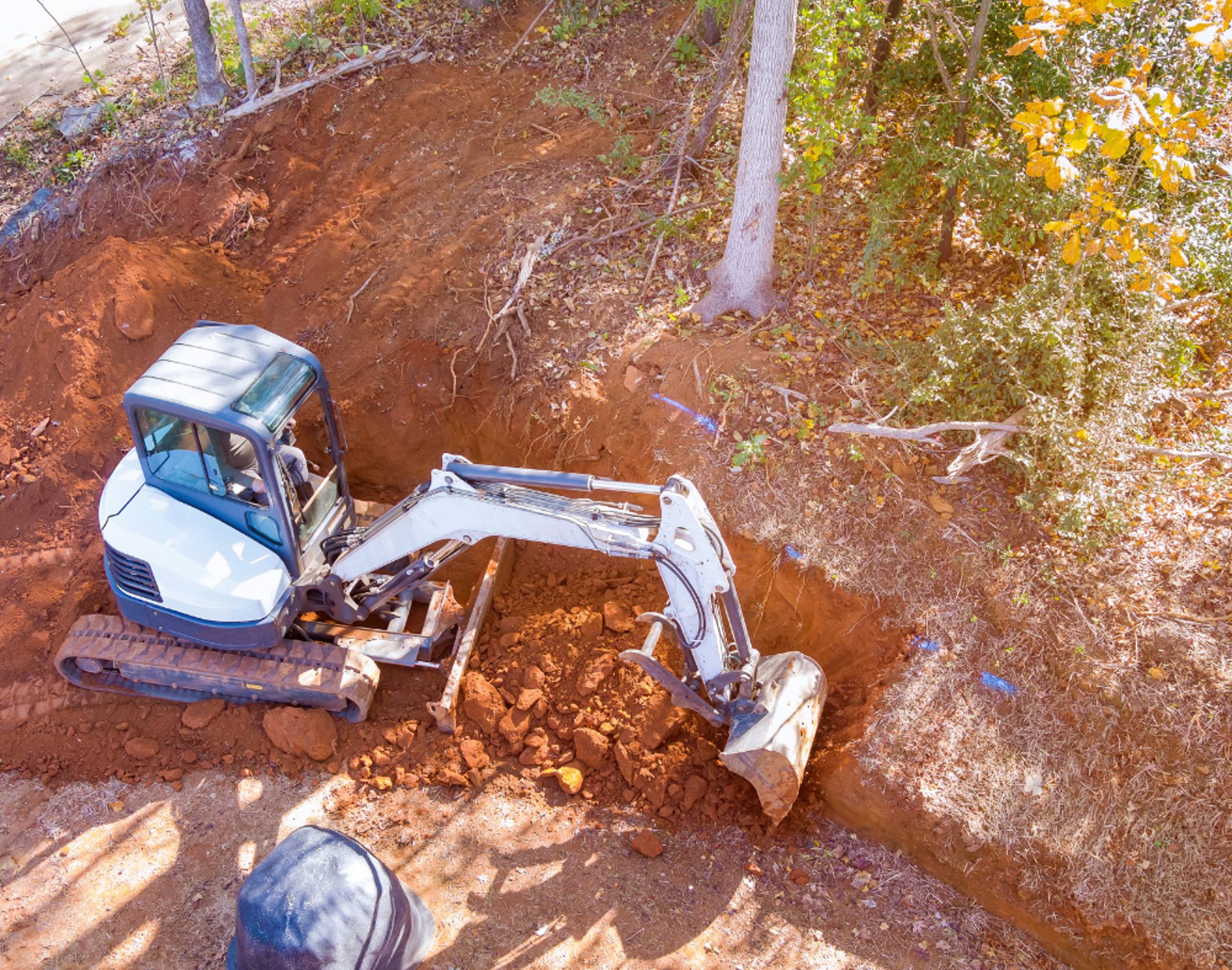 mini-excavator-digging-out-hillside.png