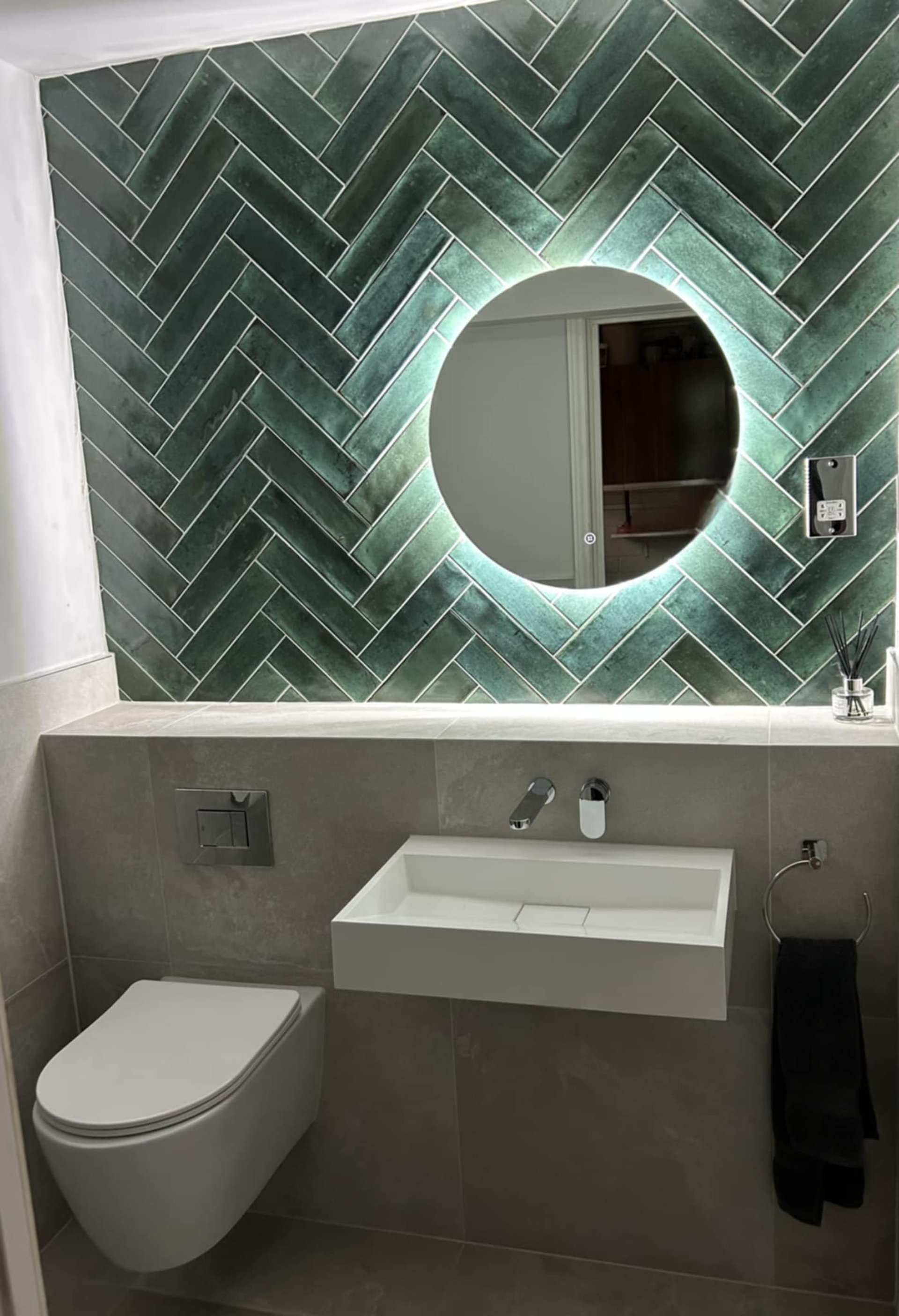 A white bathroom with a sink, toilet and mirror