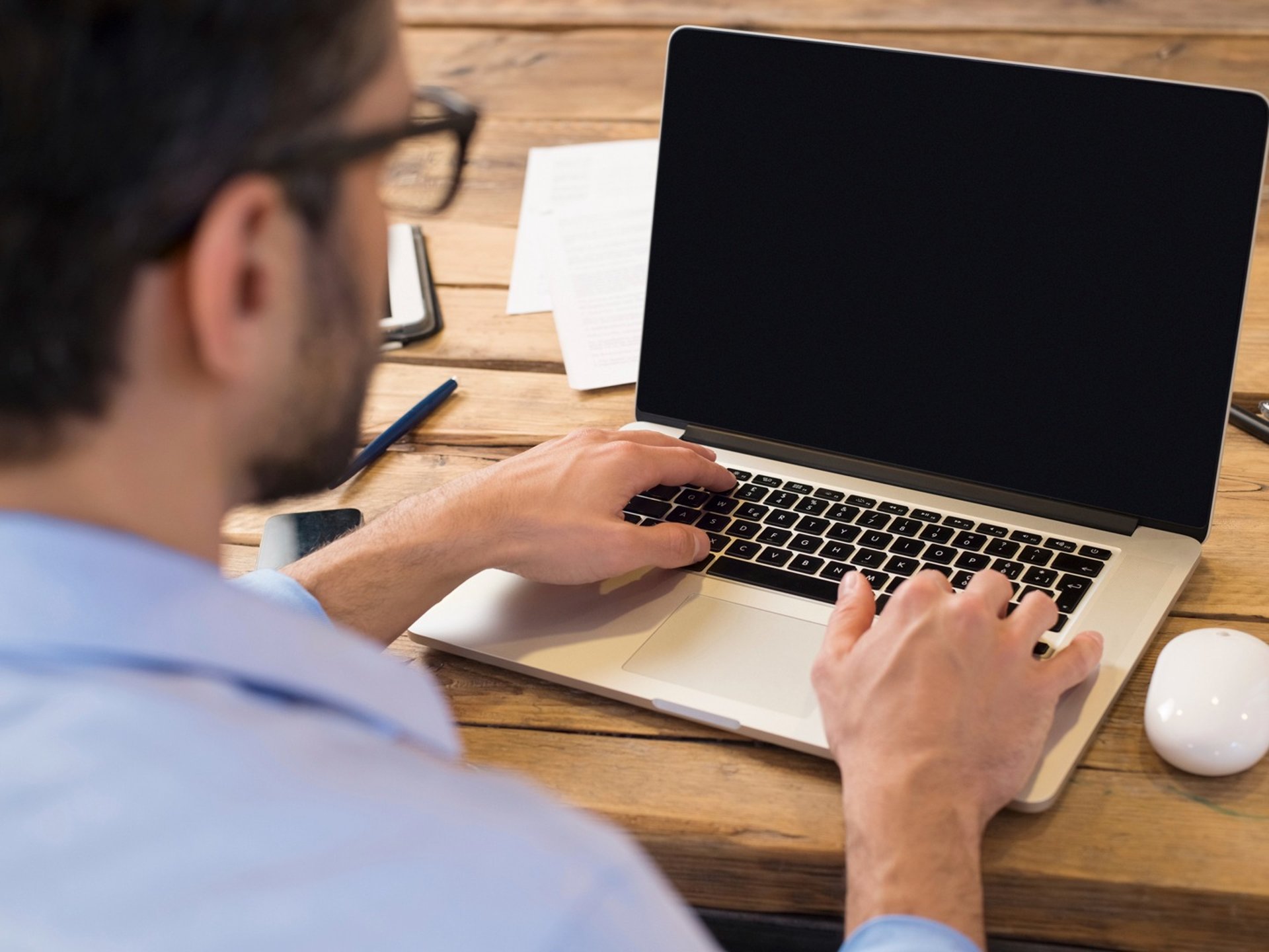 Two person at a desk intently review documents.