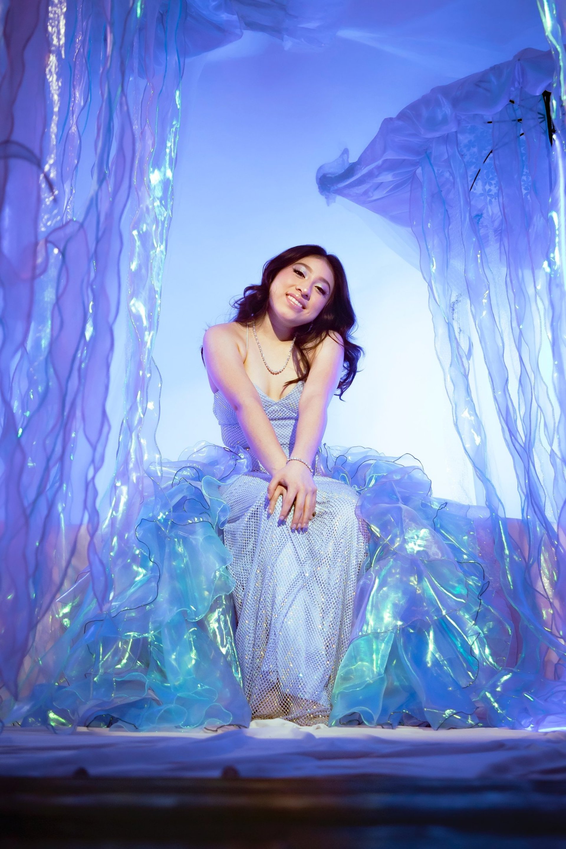 a woman in a blue dress holding a flower