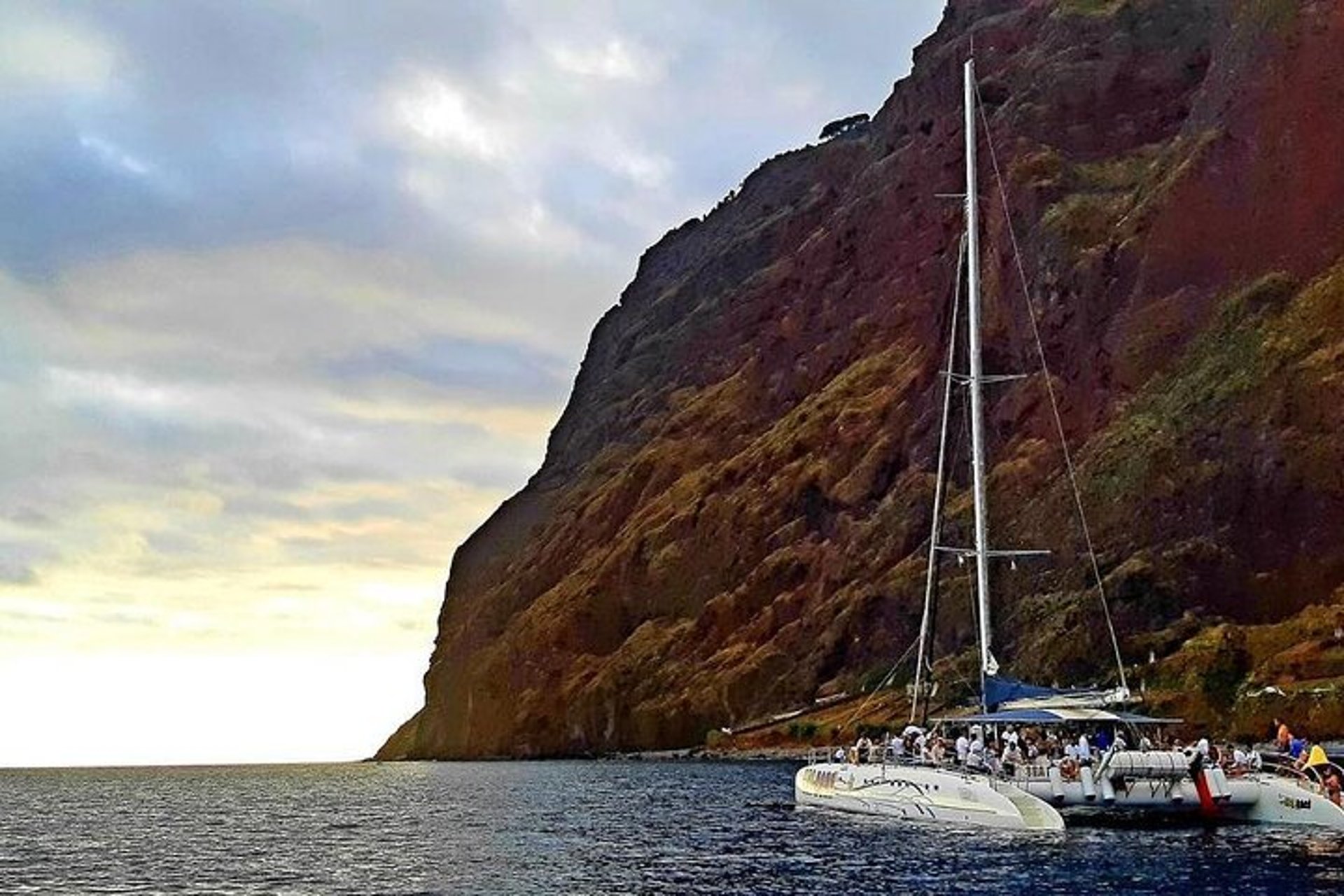 Sea Born catamaran sailing beneath the cliffs of Cabo Girão, Madeira.
