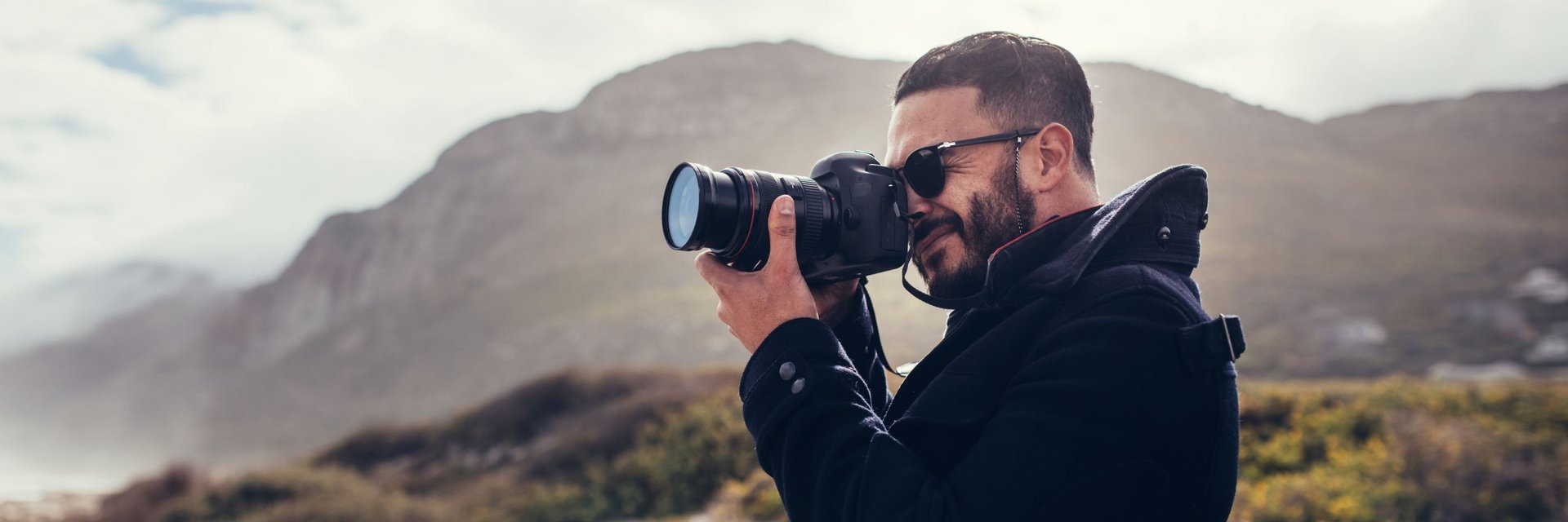 Man photographing outdoors near Cape Town mountains during a photography course session.