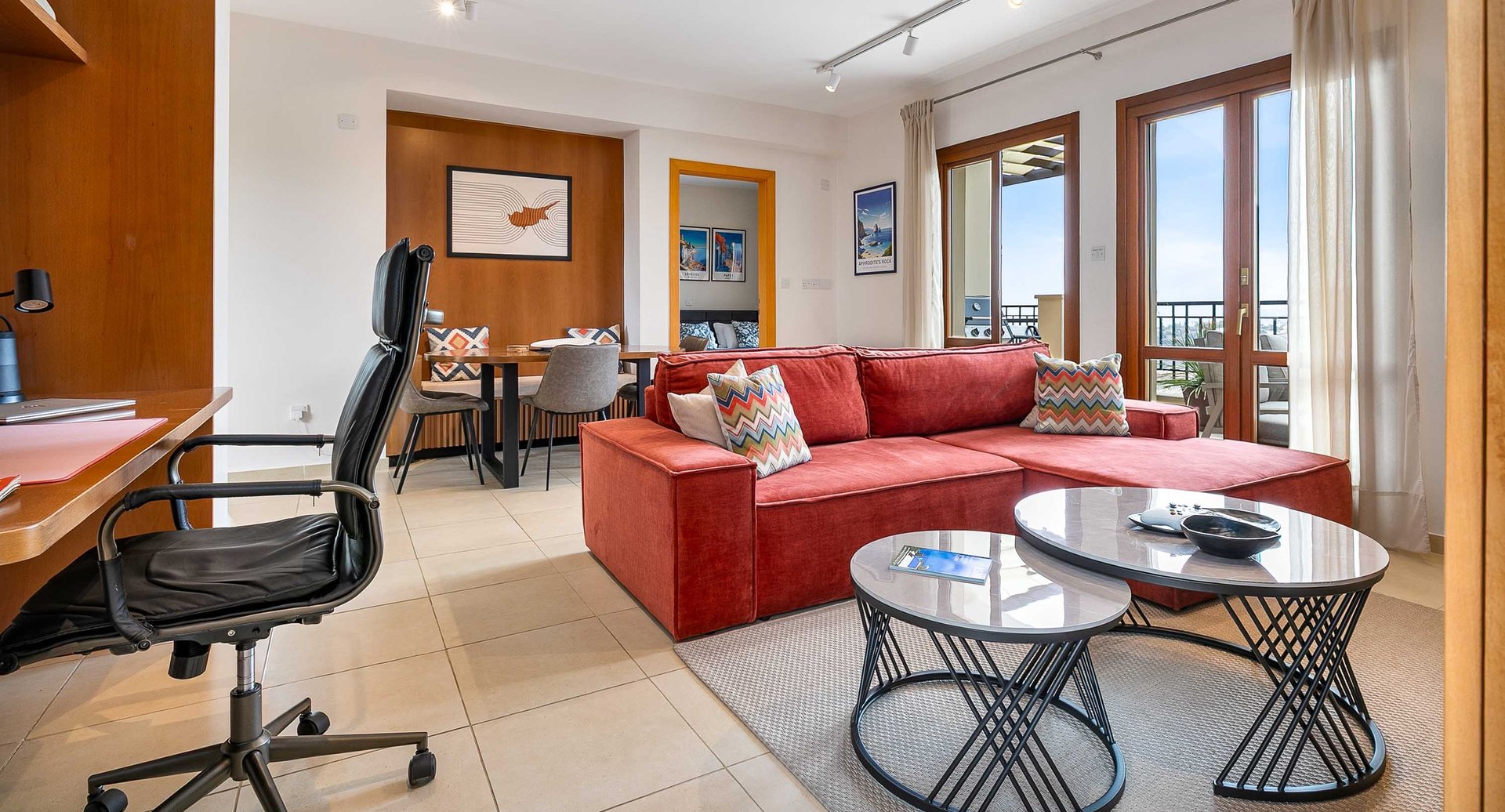 Living room seating and dining area with large TV, remote working desk and sea view at Theseus Retreat holiday rental