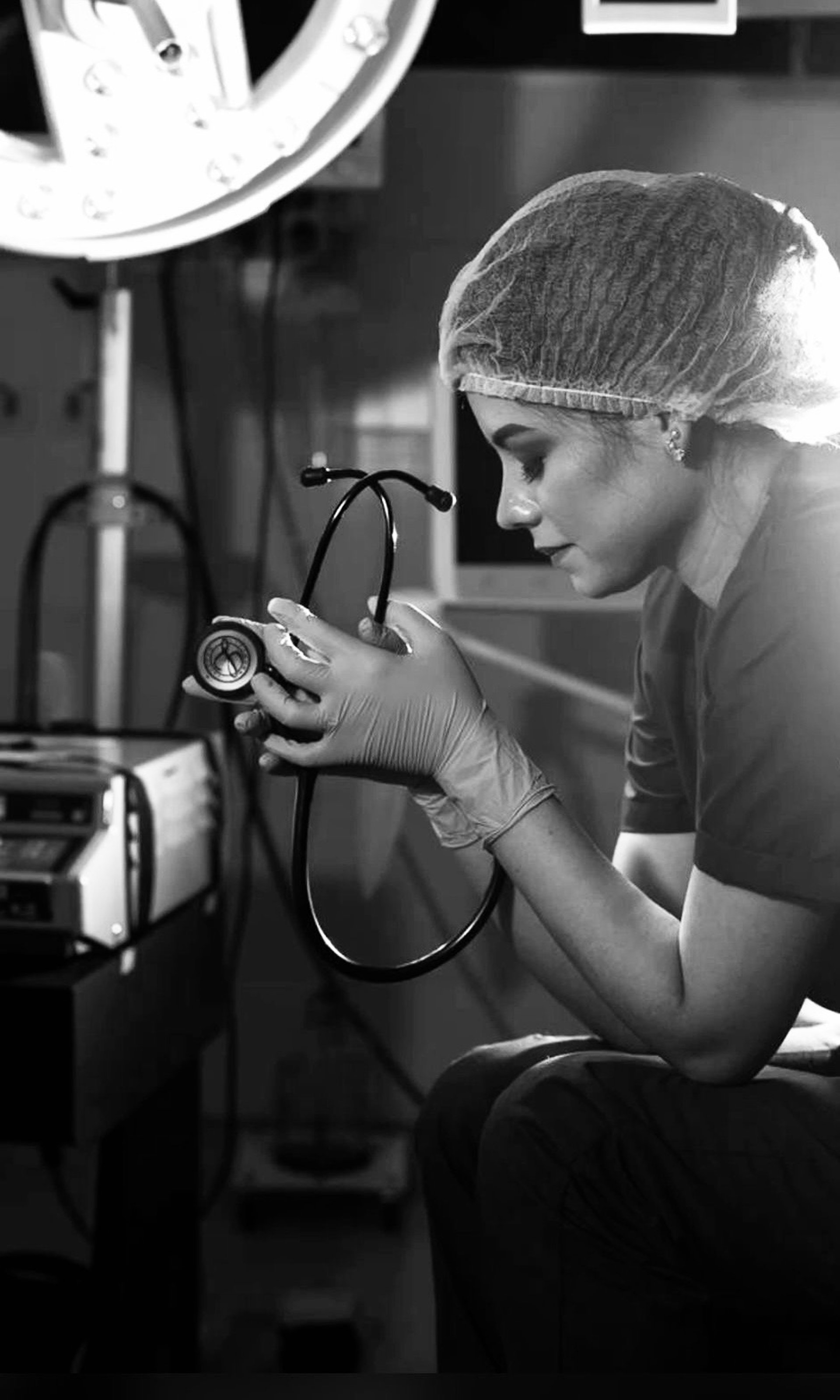 gray scale photo of three nurses and doctor about to perform surgery
