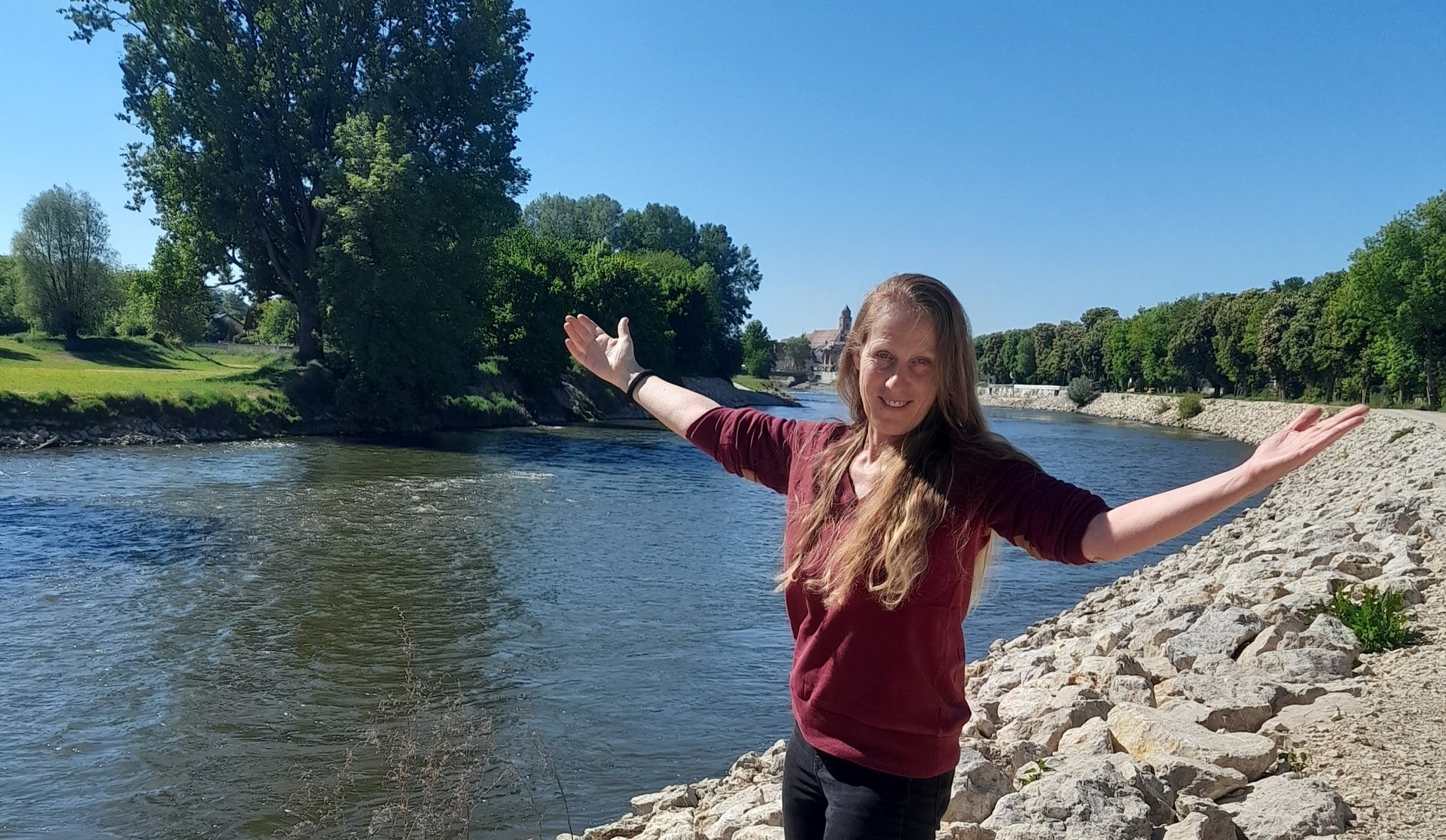 woman in gray top standing near body of water