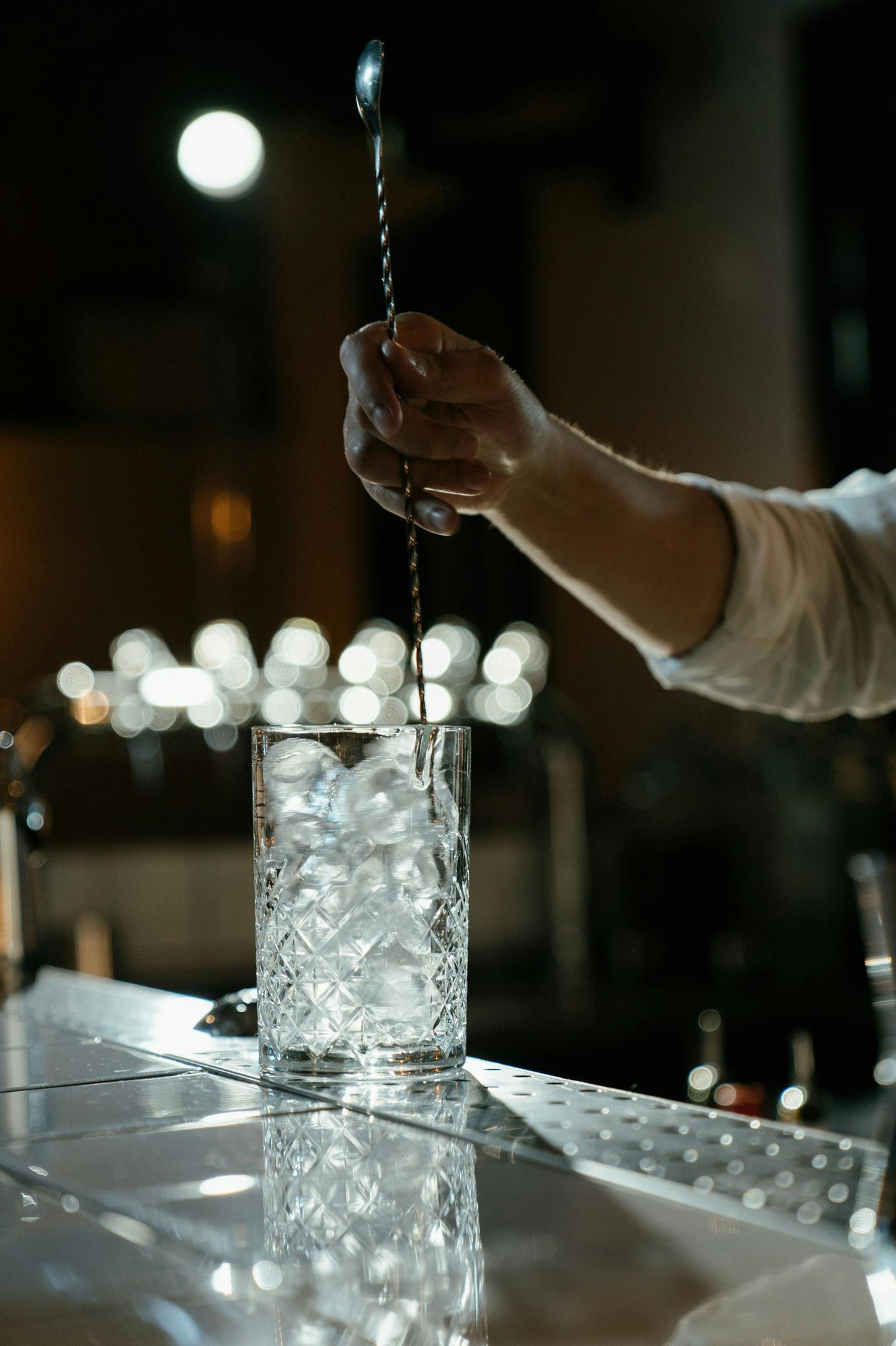 a table topped with a bottle of liquor next to a candle
