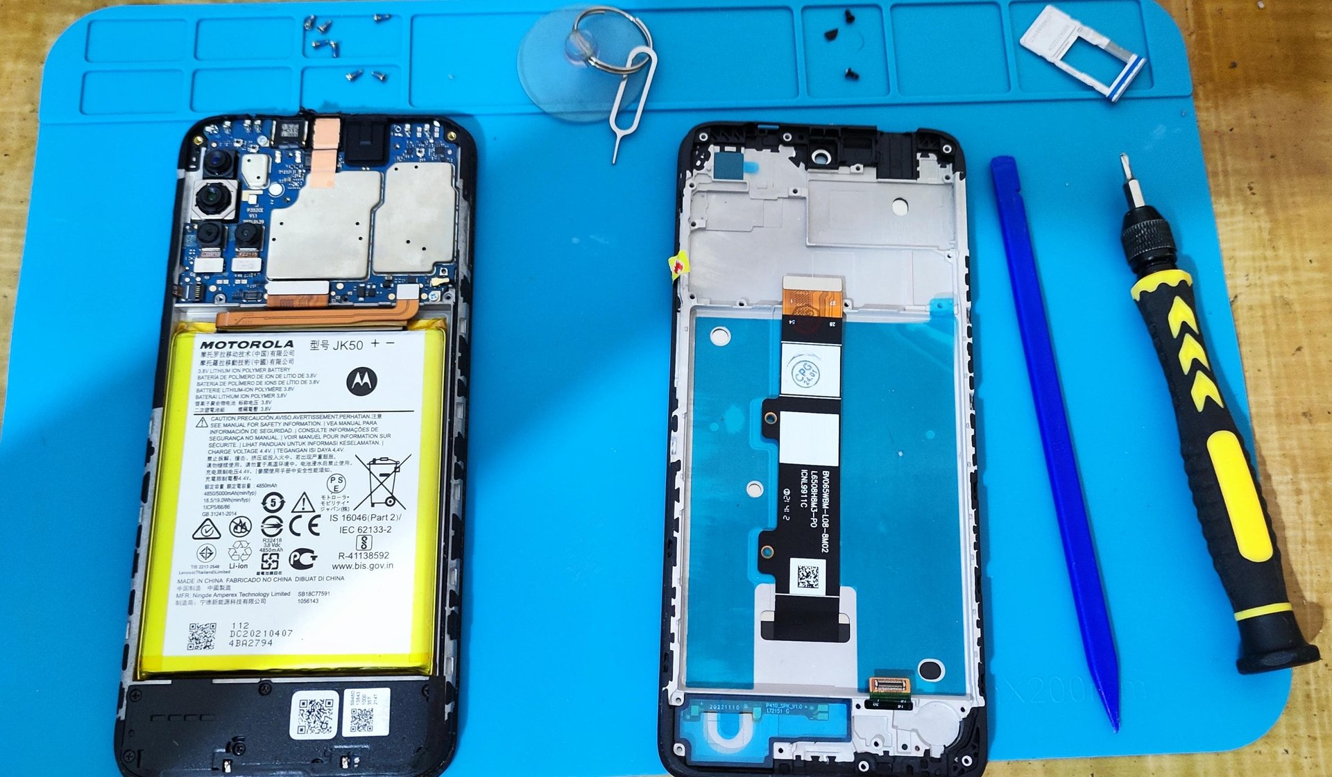 person repairing smartphones under a lighted table
