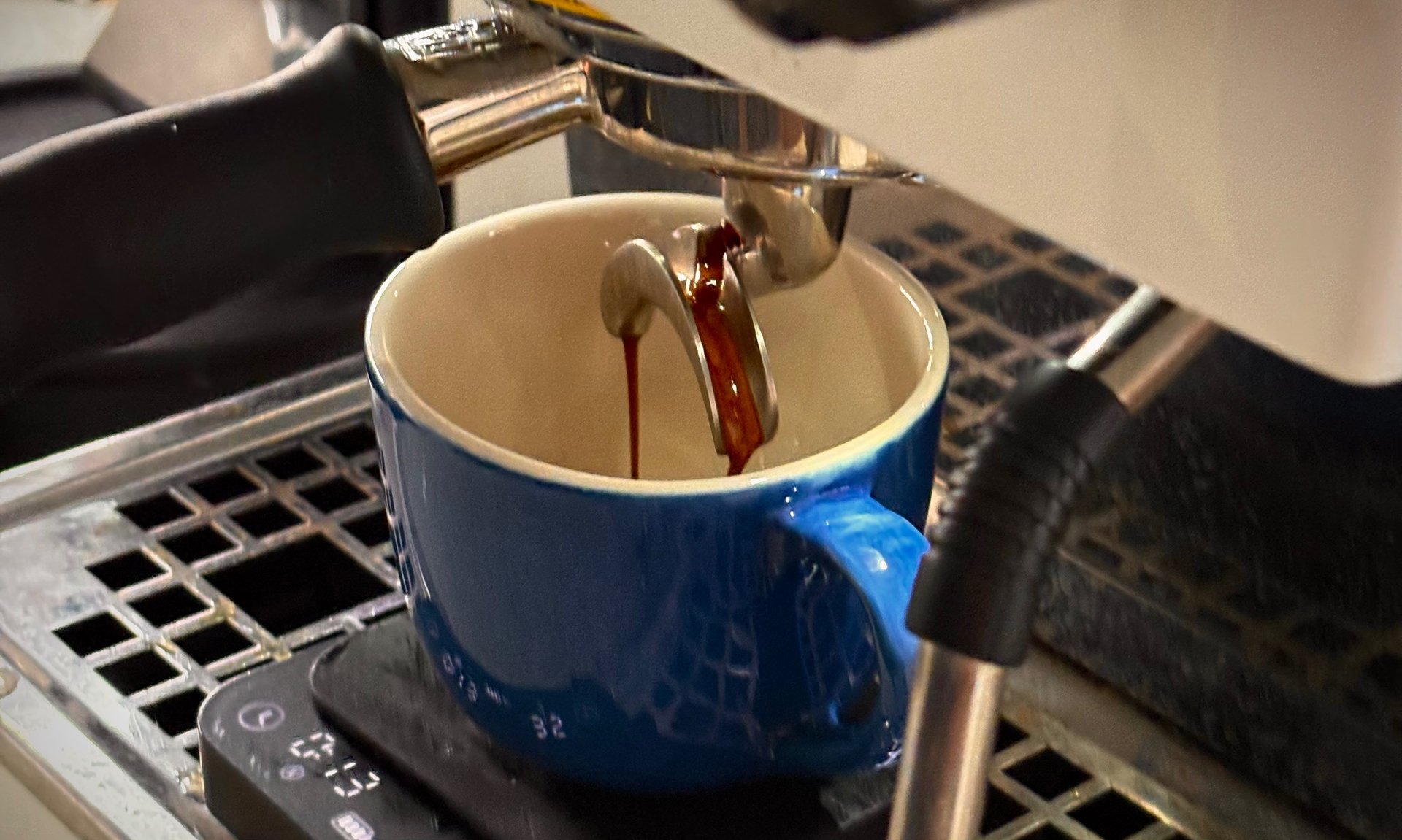 white ceramic cup on silver and black espresso machine