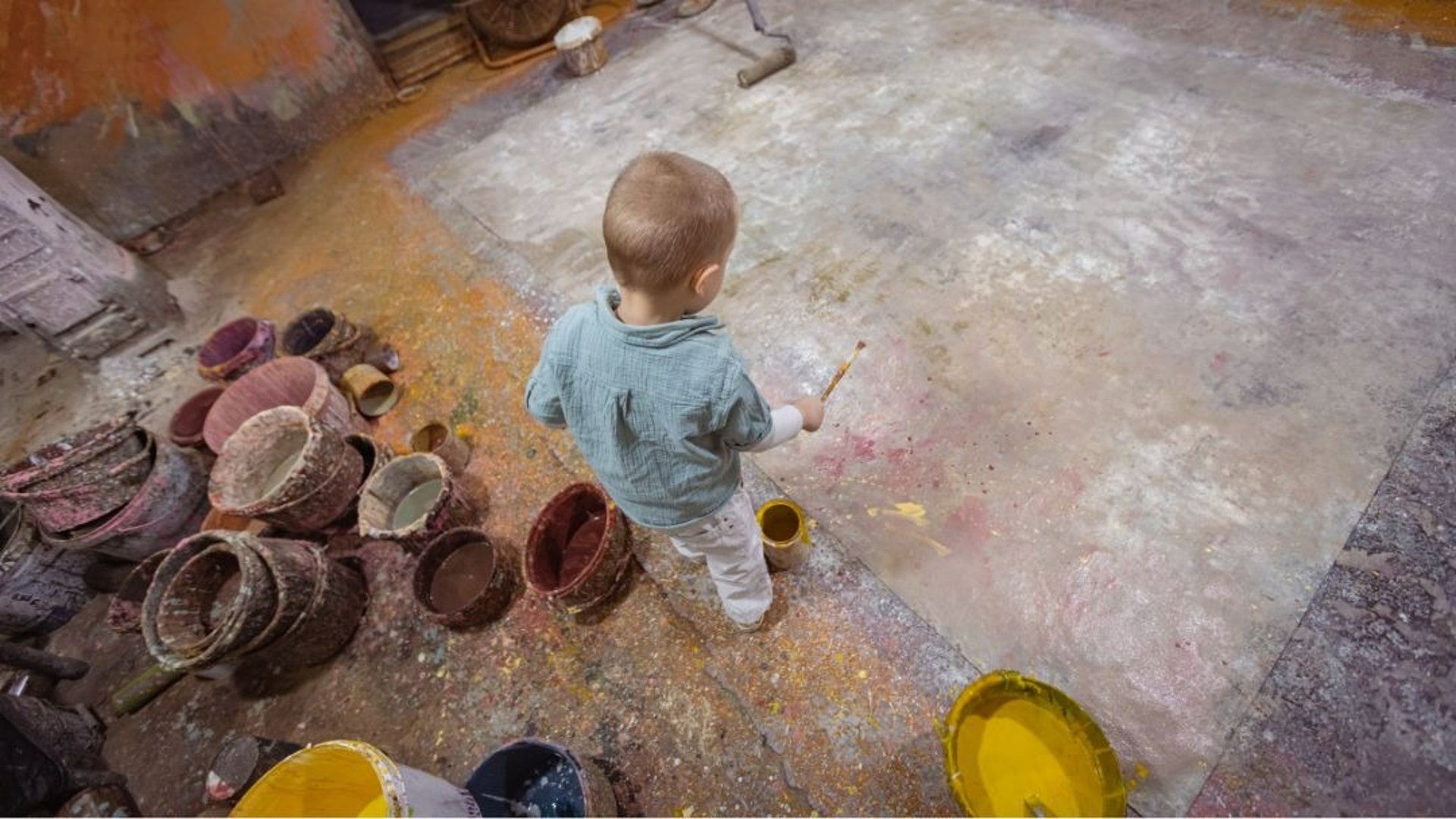 a couple of kids sitting on top of a beach next to the ocean