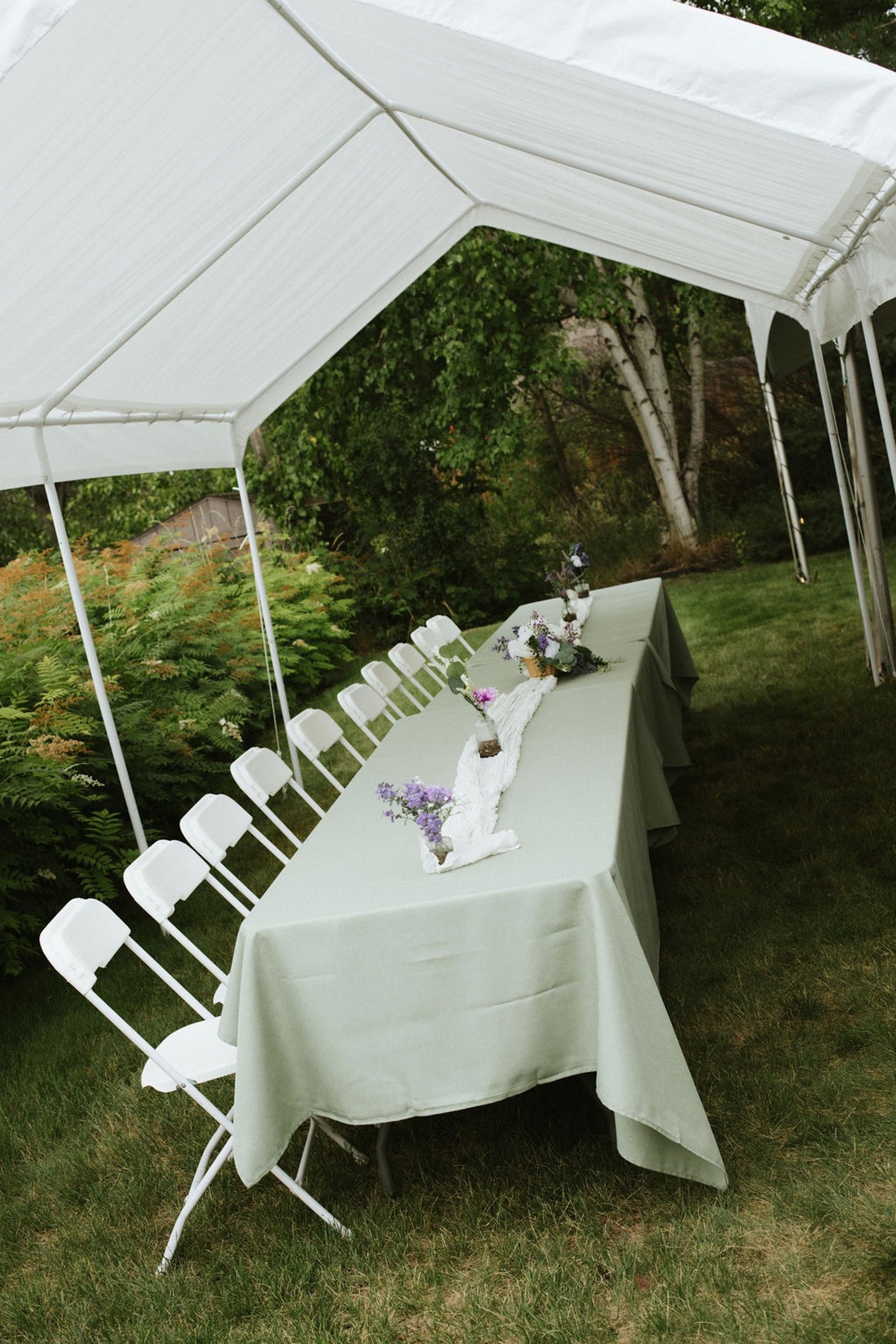 flat lay of wedding invites, his and hers vow books, and wedding bands in a wooden box