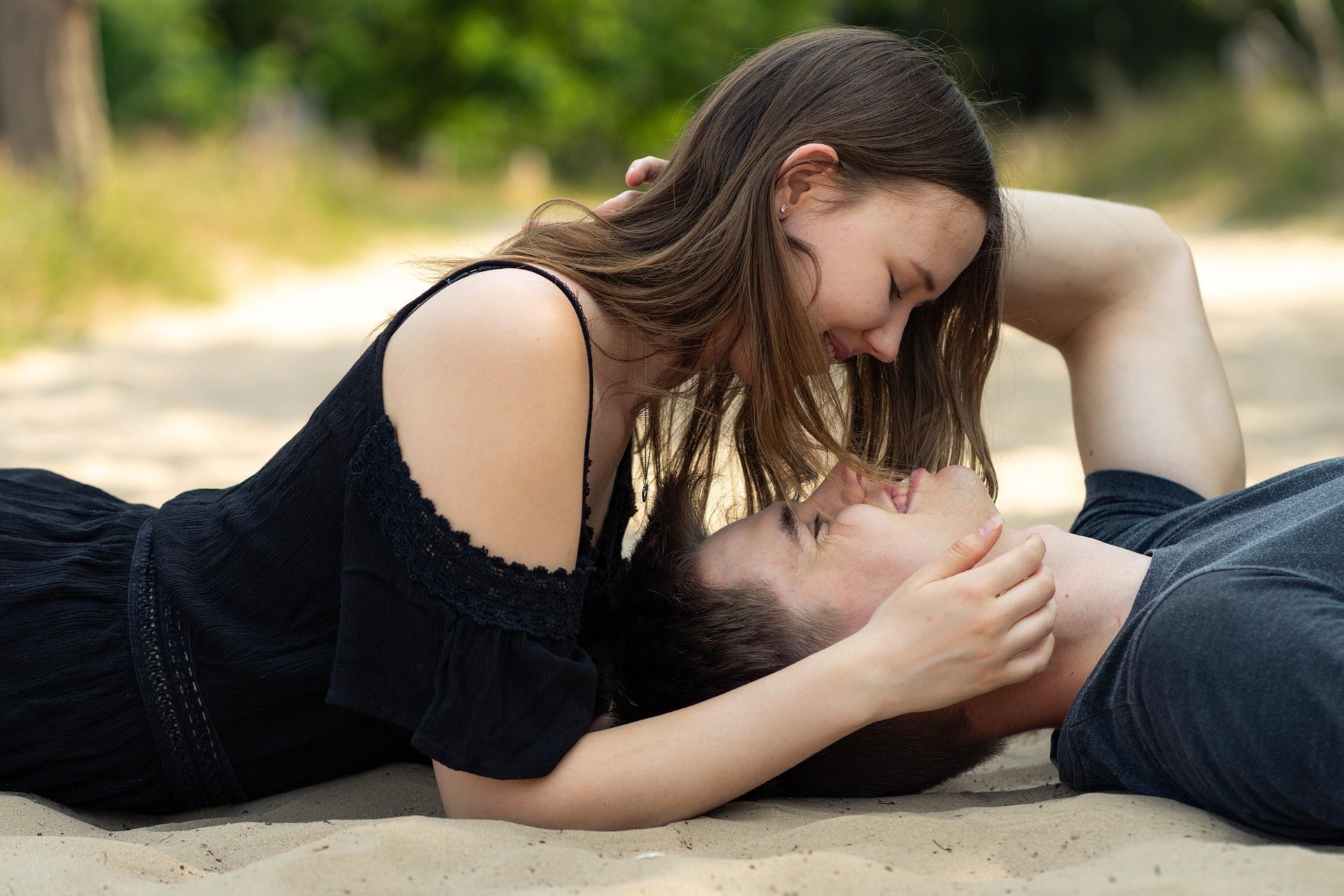 Liebespaar liegt sich am Strand romantisch gegenüber. Intime Paarfotografie von Just Perspectives.