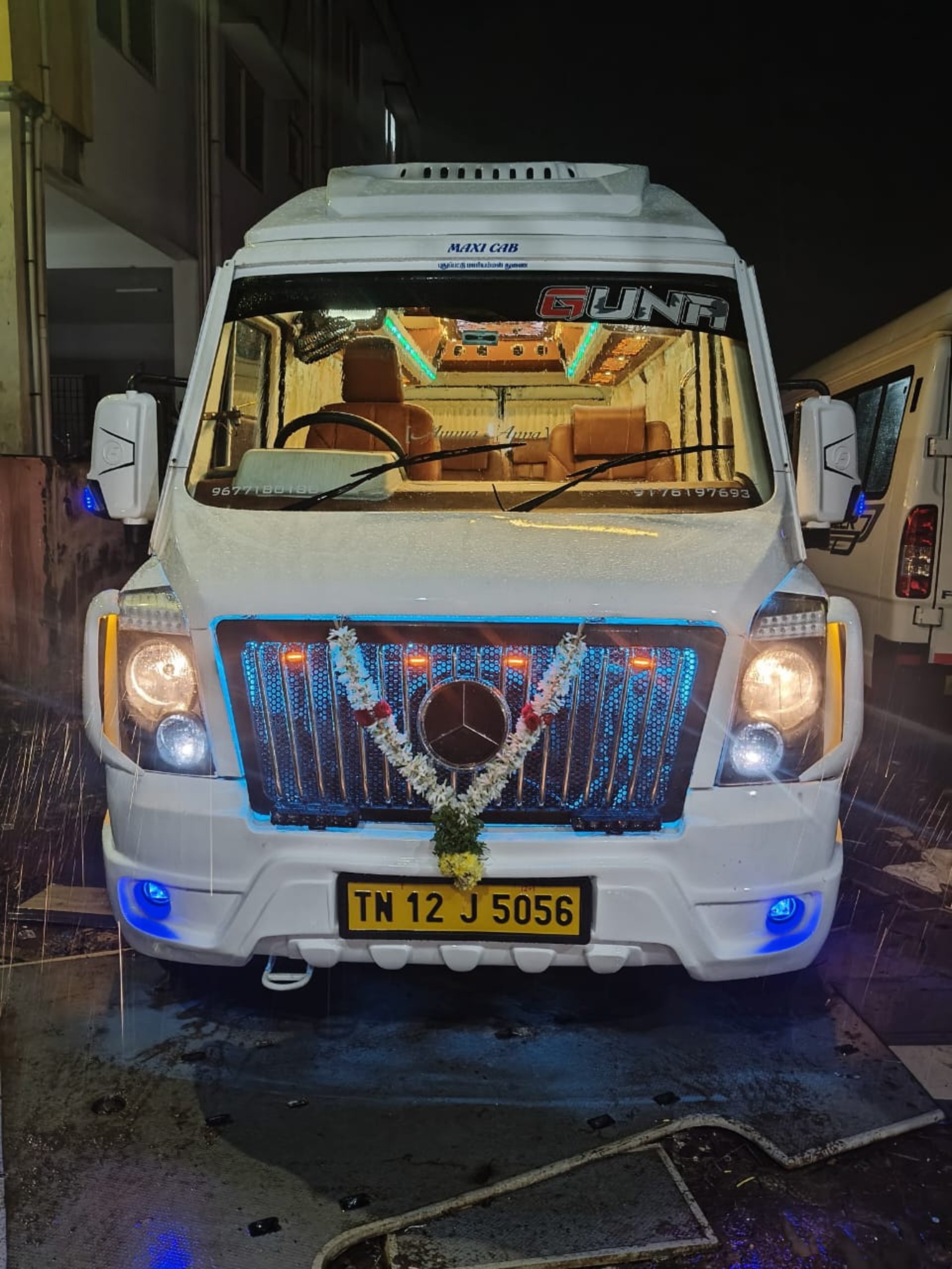 a blue bus driving down a street next to a tall building