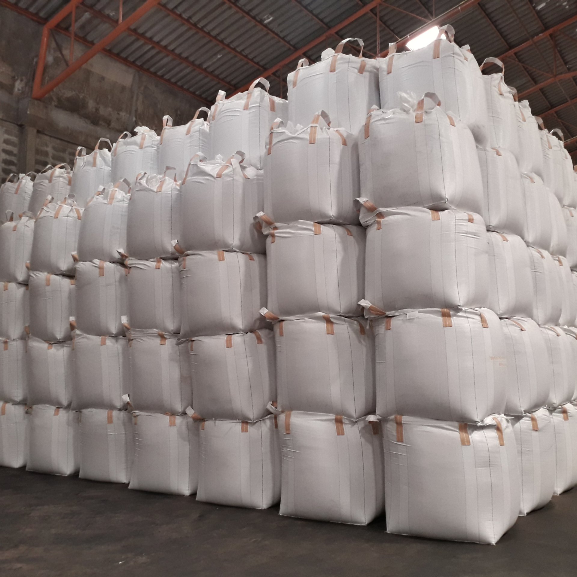 a warehouse filled with stacks of white bags