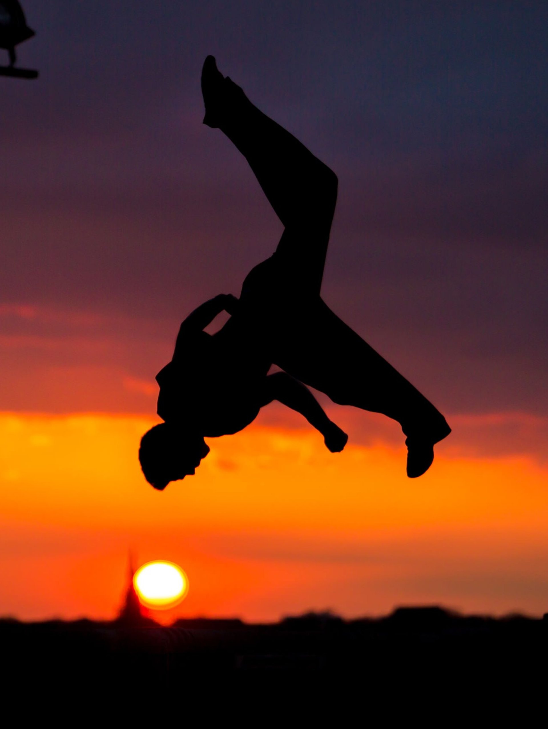 a man in the air doing a trick on a surfboard