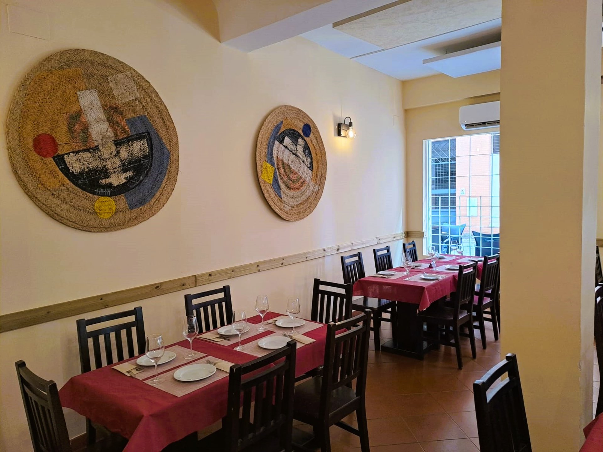 Zona interior del Bar Las Tinajas Huelva, con mesas de restaurante, decoración en la pared y ambiente acogedor.