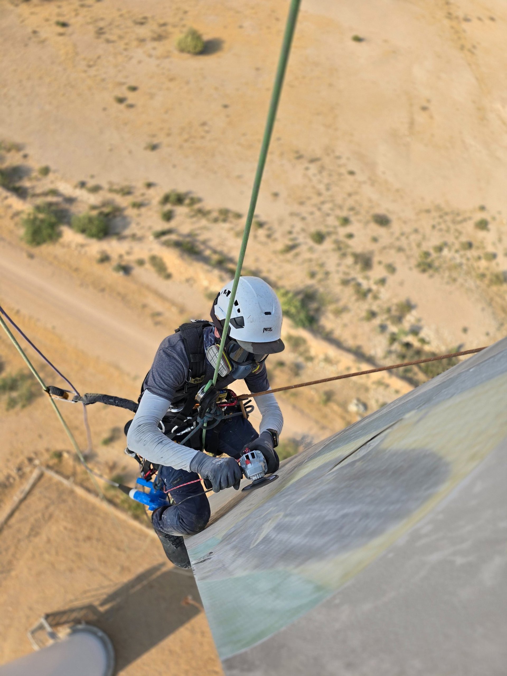 A man on a high wire working on a building