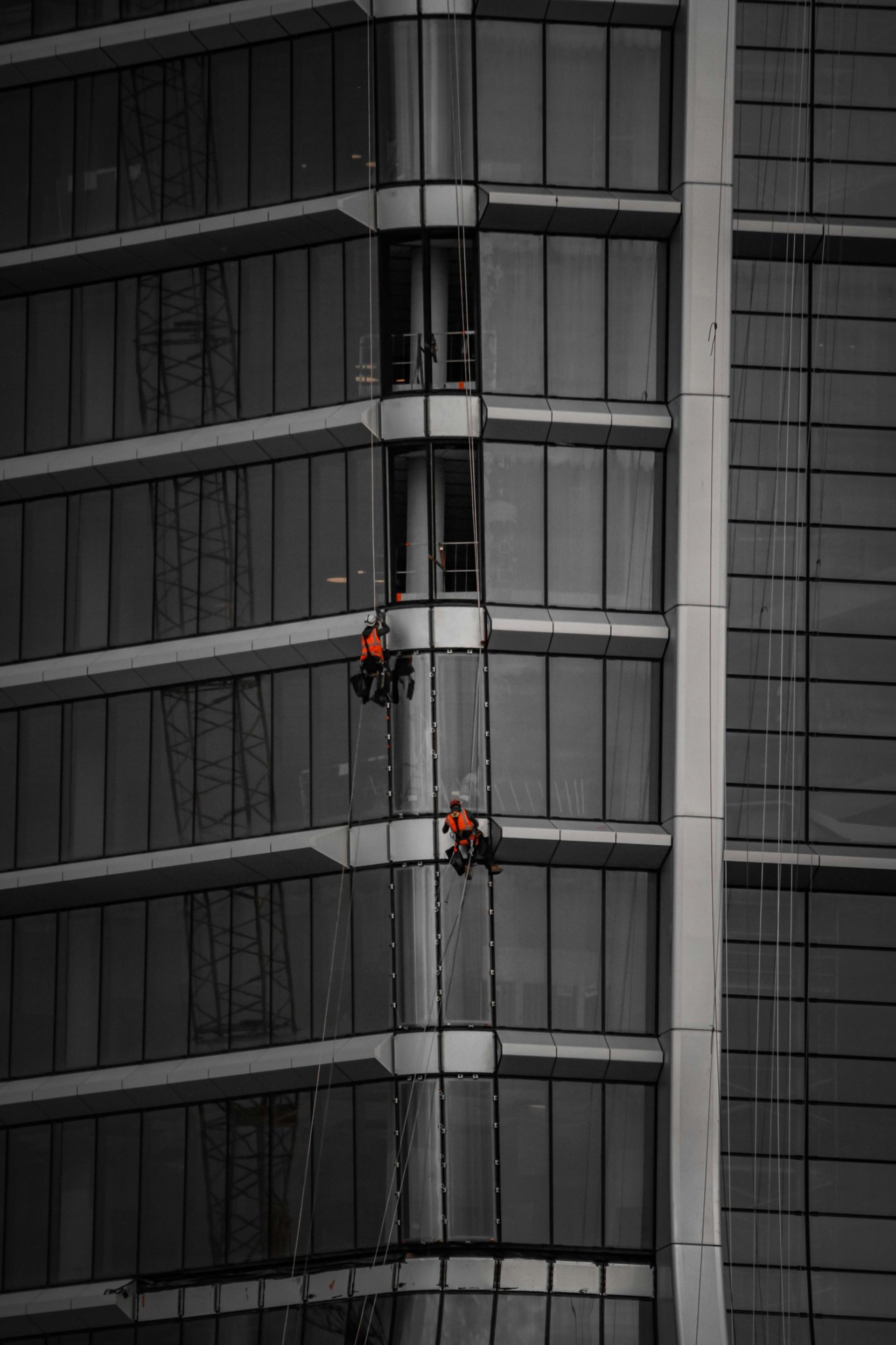 A man on a high wire working on a building