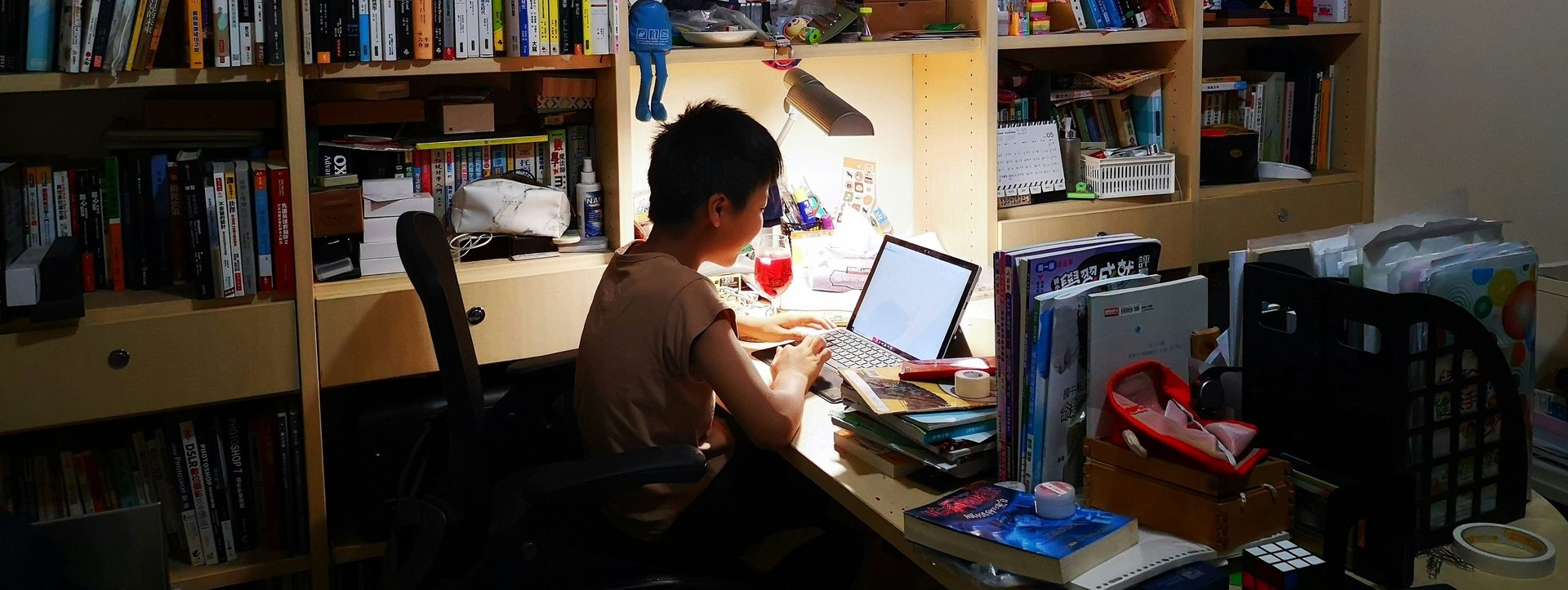A woman sitting at a table with a laptop wearing headphones