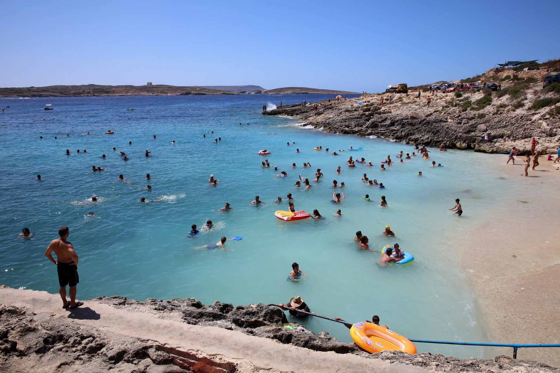 Hondoq Beach, with several people enjoying the water. 