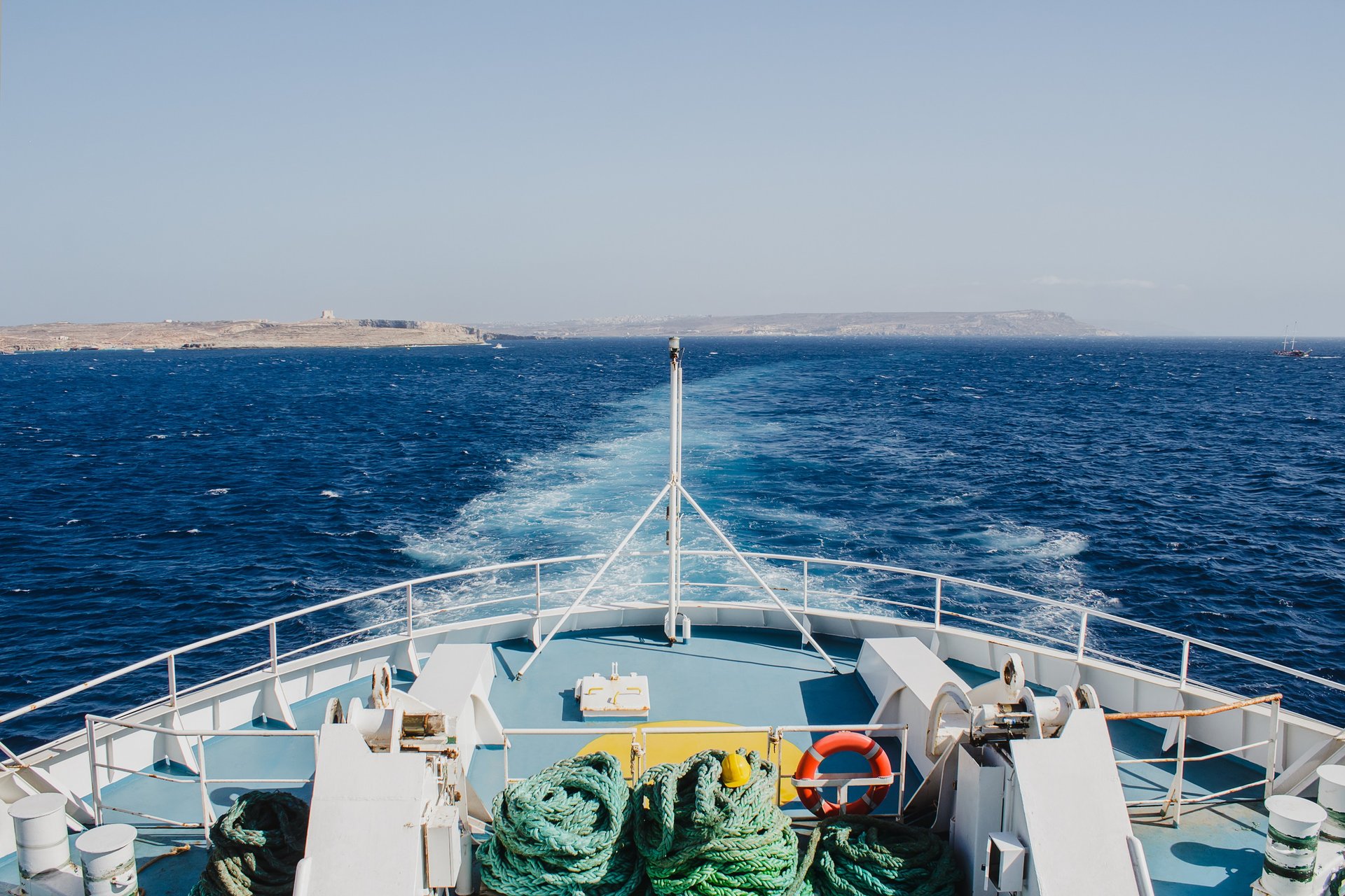 Prow of a Gozo Channel Ferry against the backdrop of the sea. With Comino and Malta in the distance.