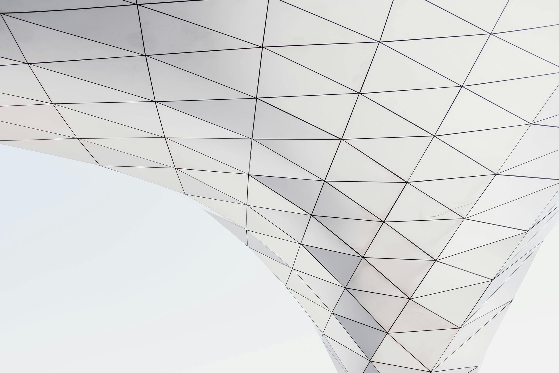 an abstract photo of a curved building with a blue sky in the background