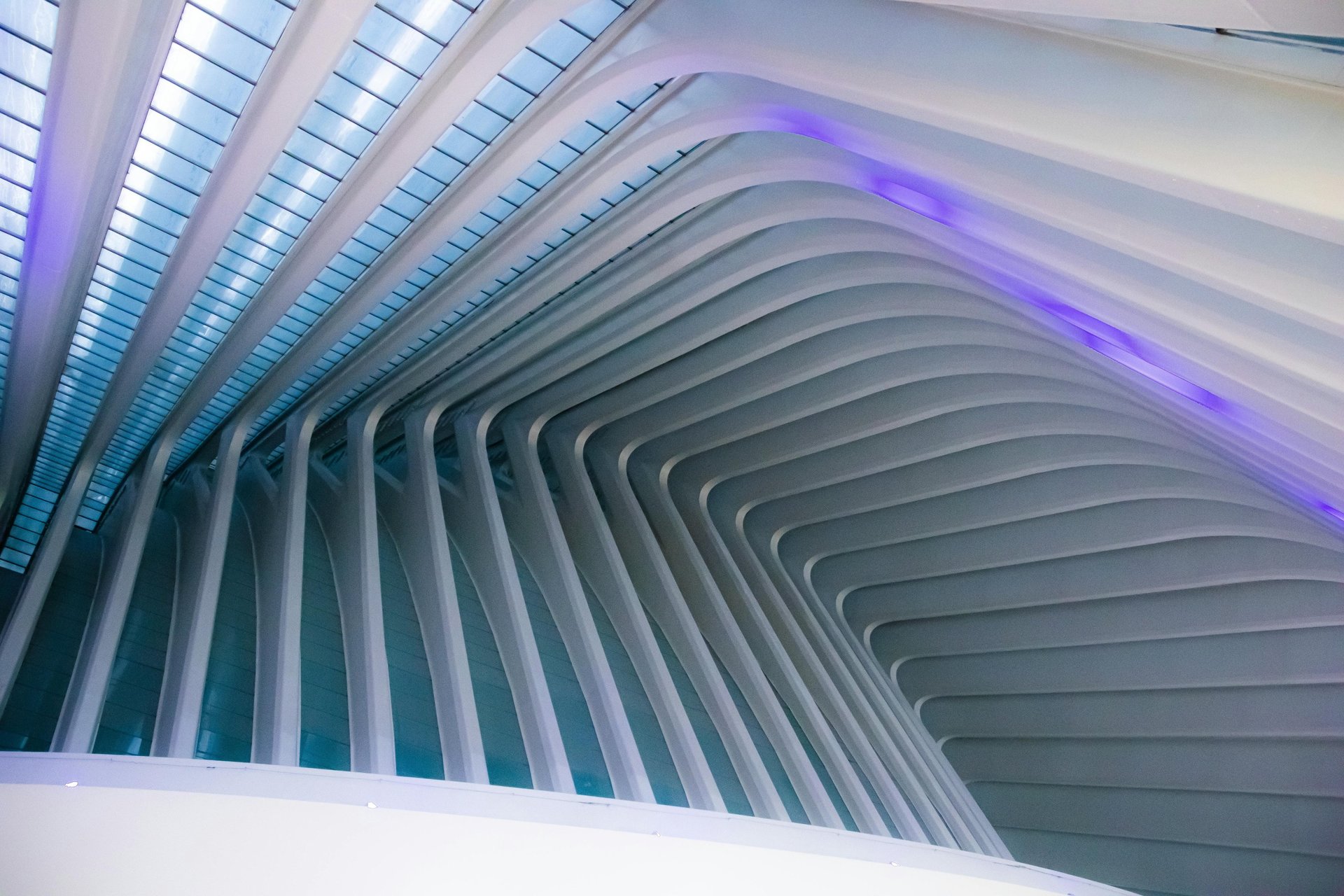 an abstract photo of a curved building with a blue sky in the background