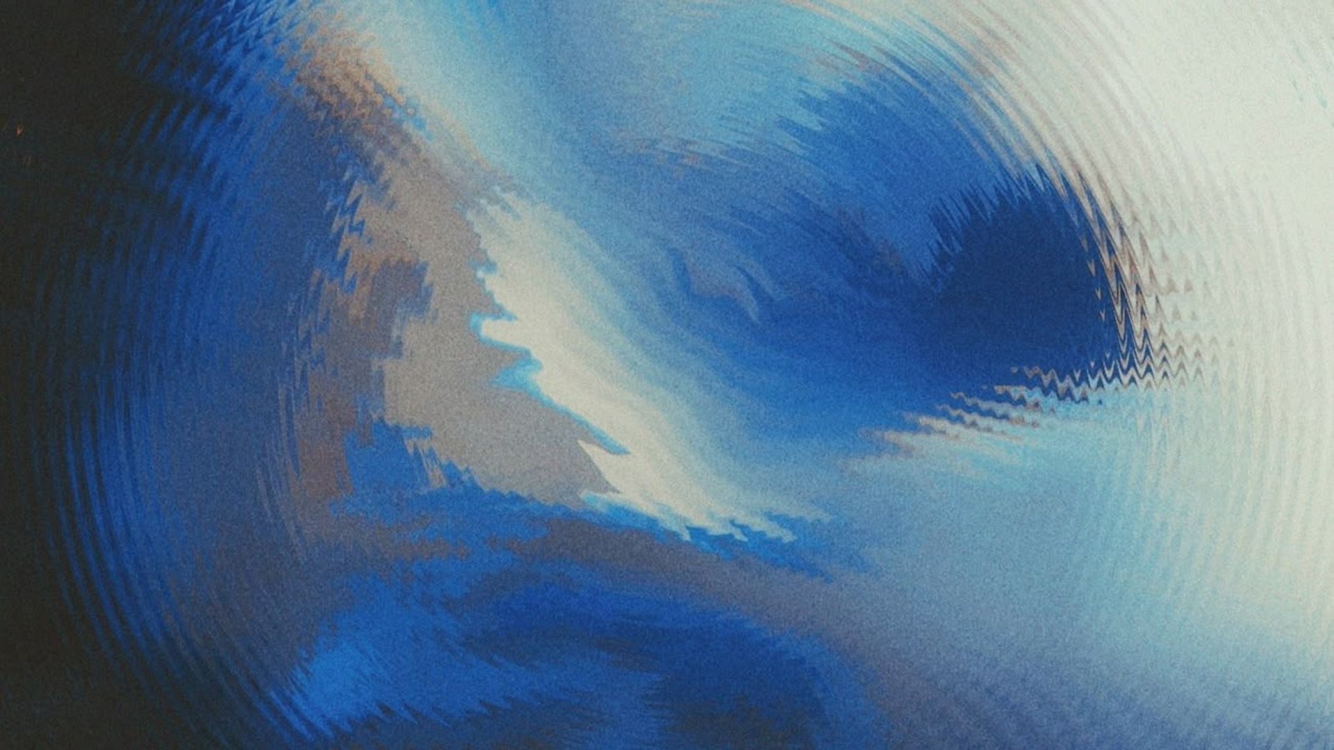 an abstract photo of a curved building with a blue sky in the background