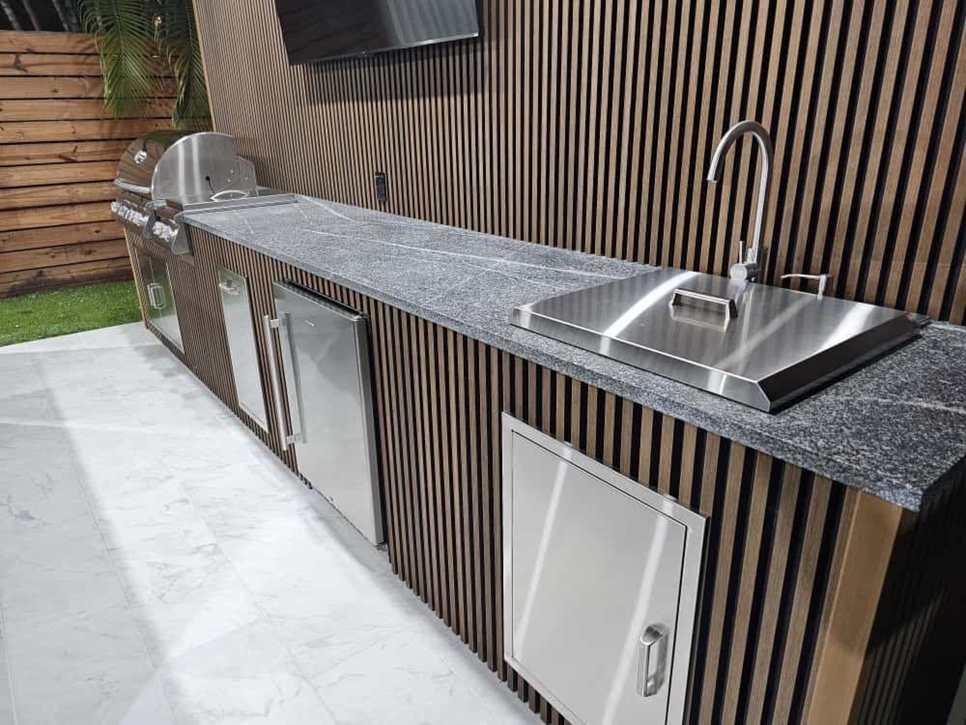 a kitchen with white cabinets and marble counter tops