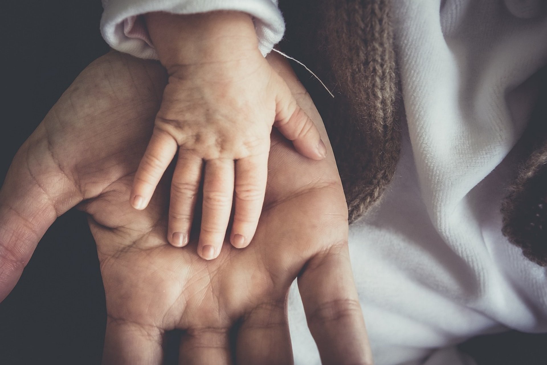 a black and white photo of a person holding a baby