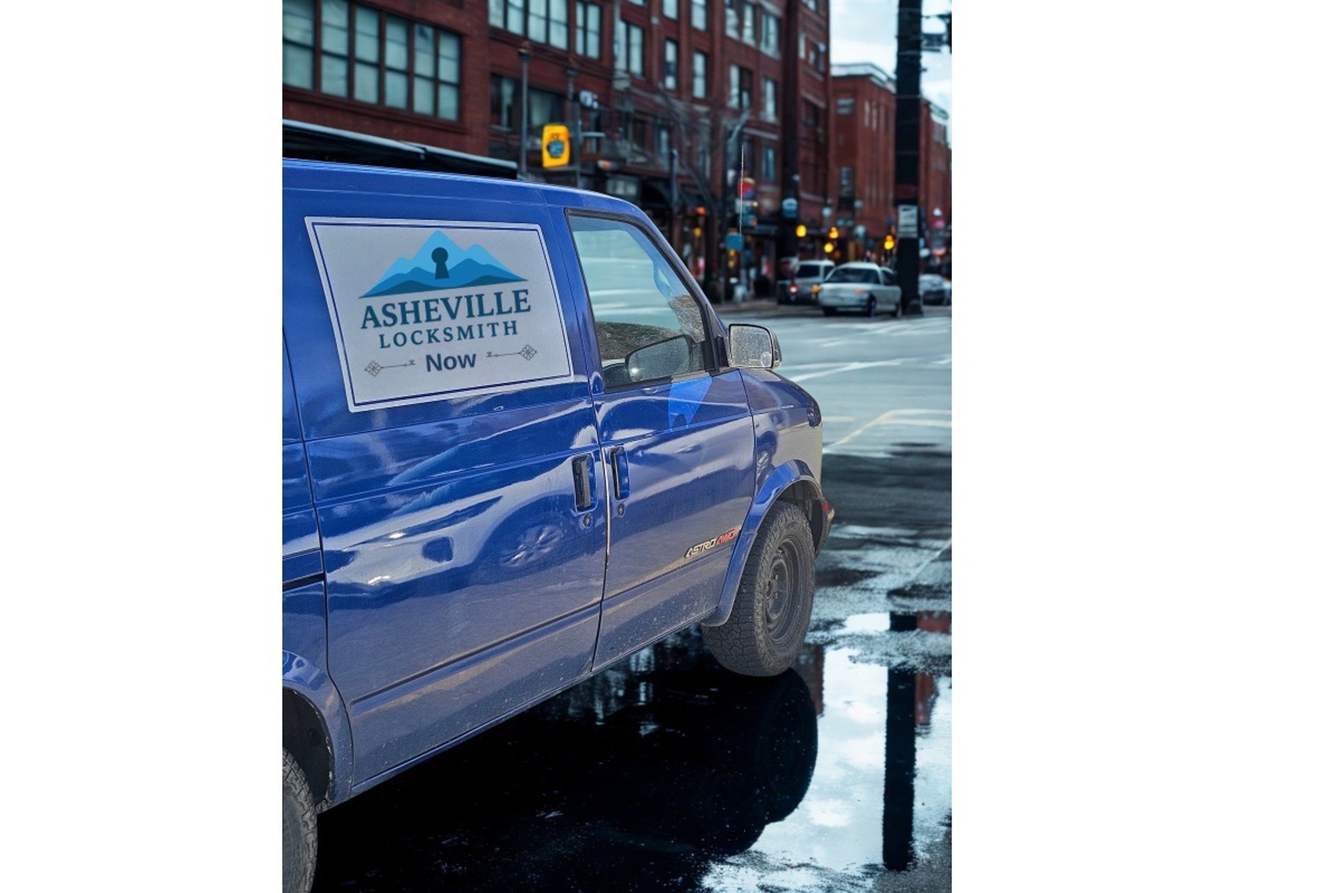 Blue work van with Asheville Locksmith logo driving through West Asheville