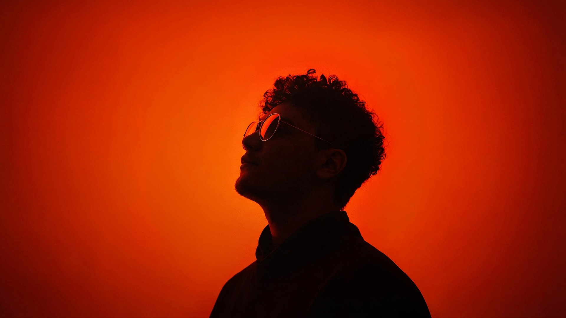 A man wearing glasses and a denim jacket