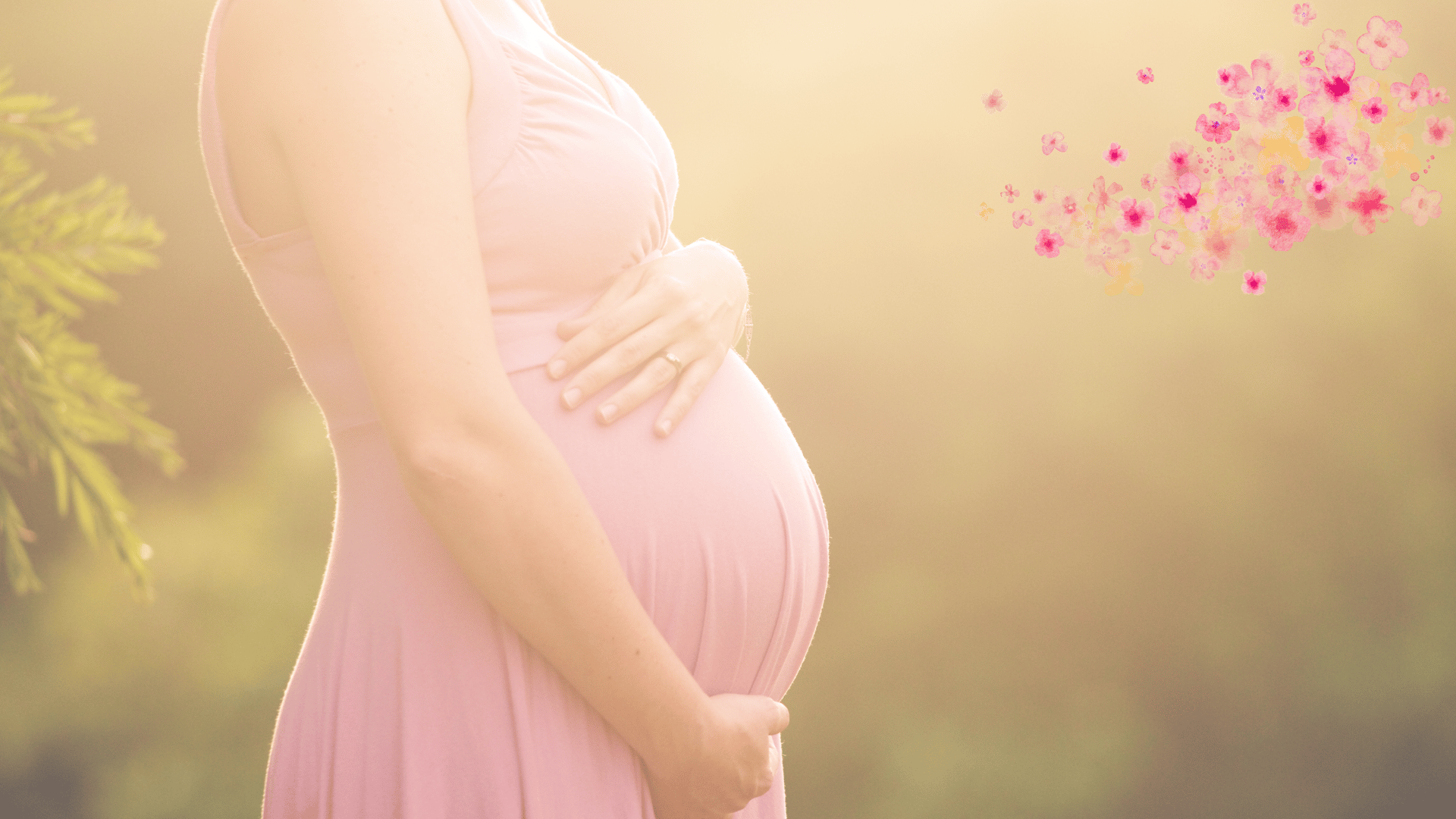 a pregnant couple standing in a field with their hands on their stomach