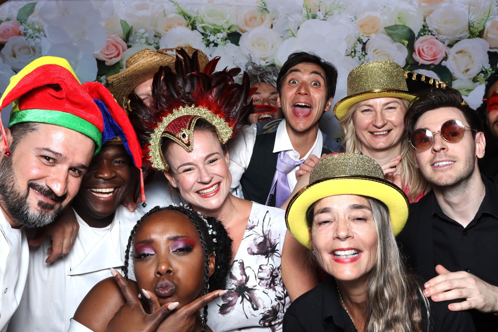 Guests at a Get The Picture UK event smiling with a photo booth strip, under vibrant party lights