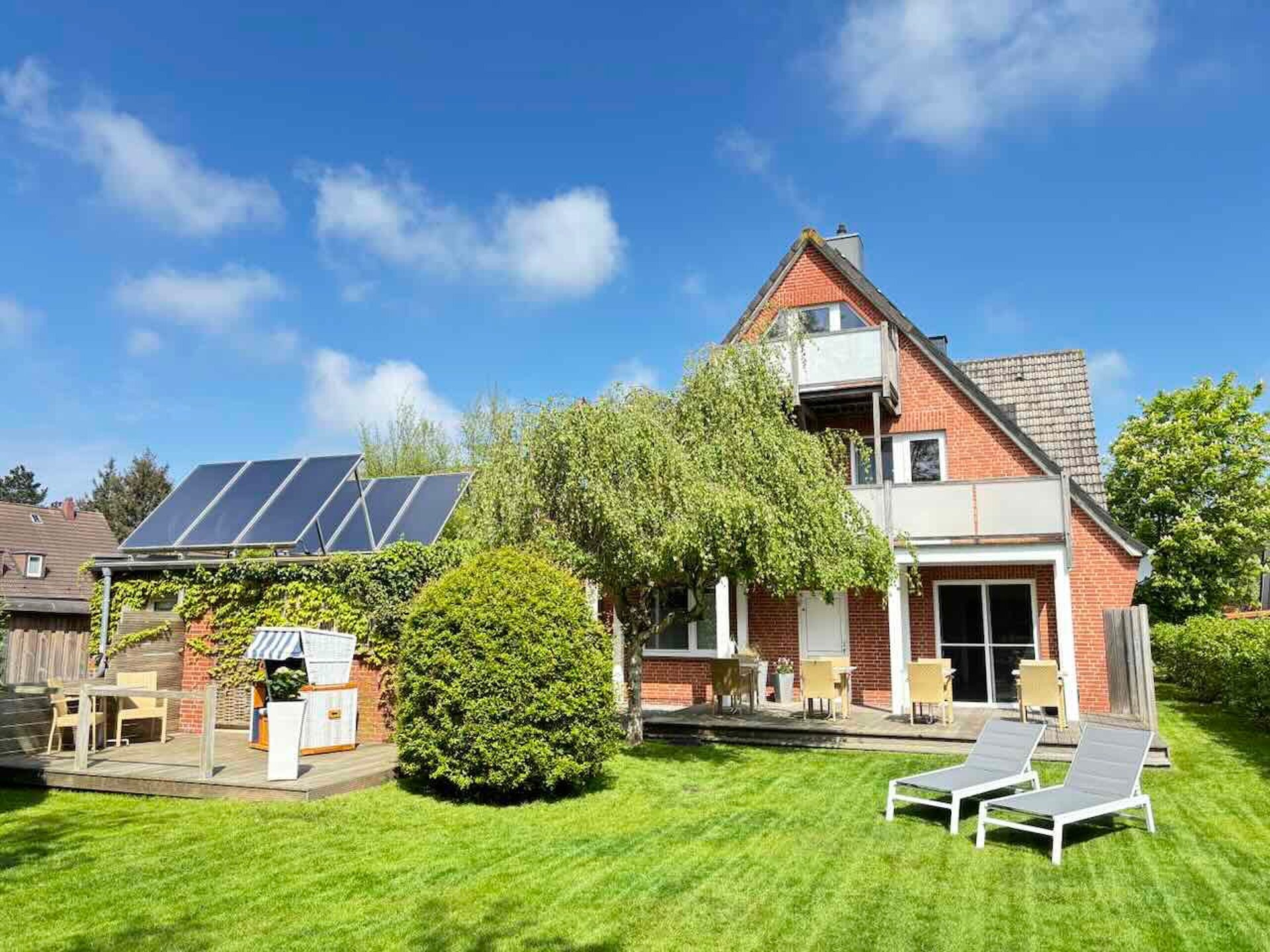 Hotel DunenNest - Gartenansicht, Liegewiese mit Liegen