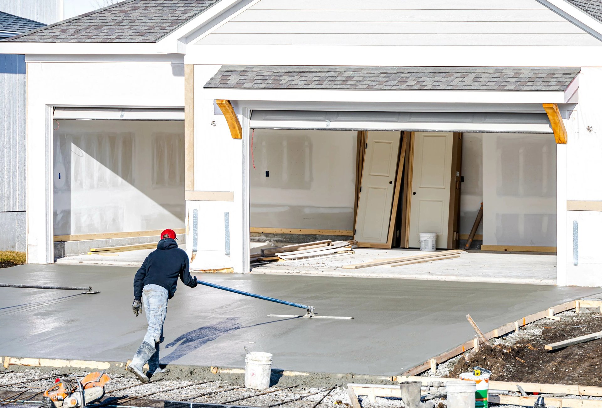 Man working on a freshly poured concrete driveway in Riverton, UT