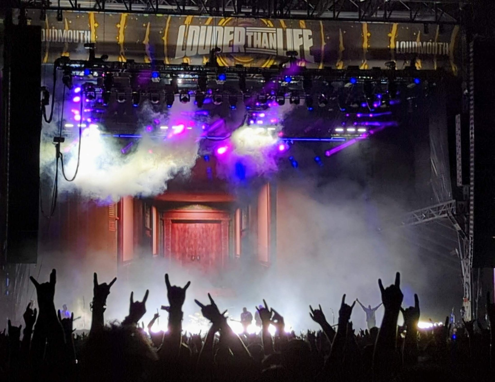 a crowd of people raising their hands in the air
