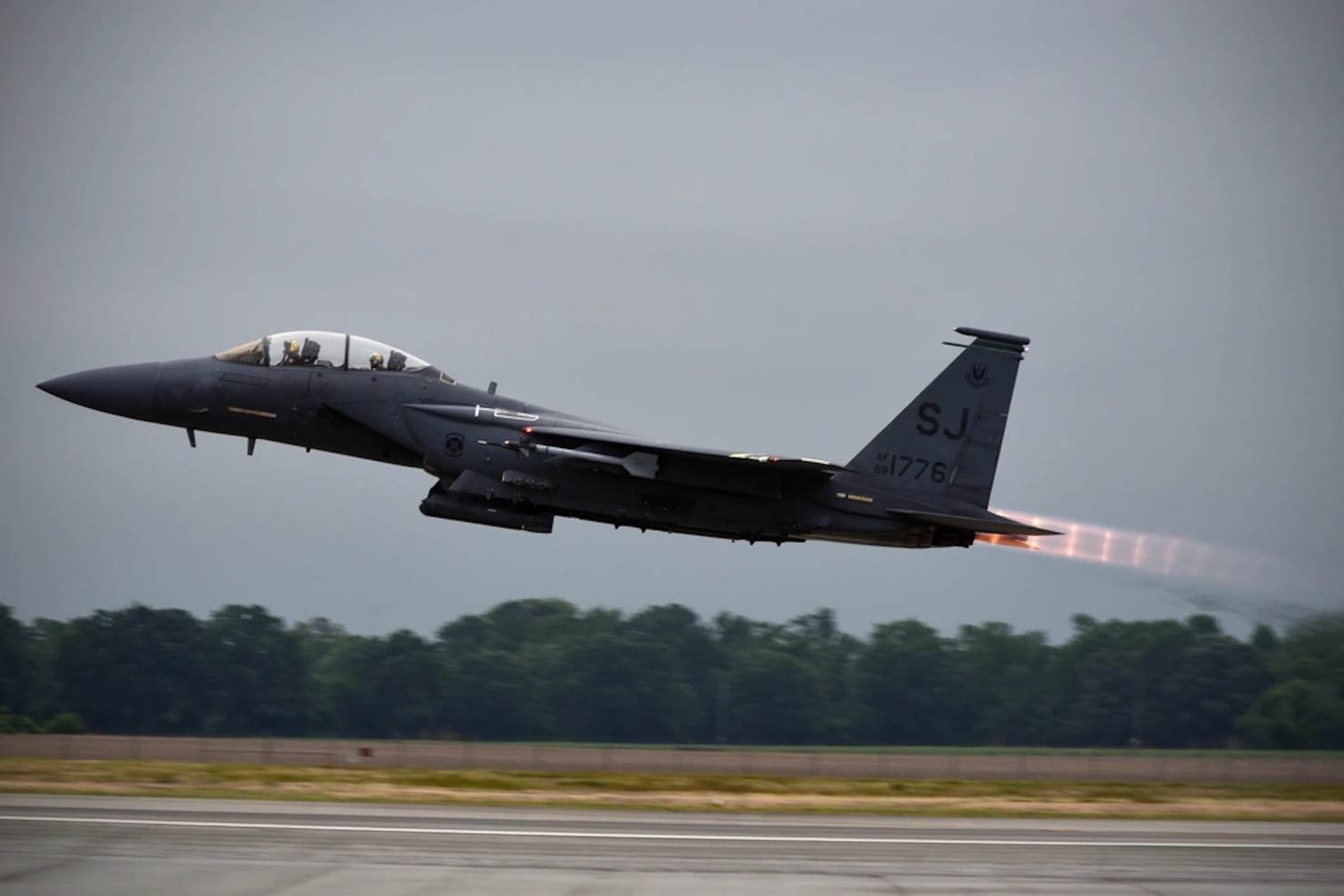 a fighter jet flying through a cloudy sky