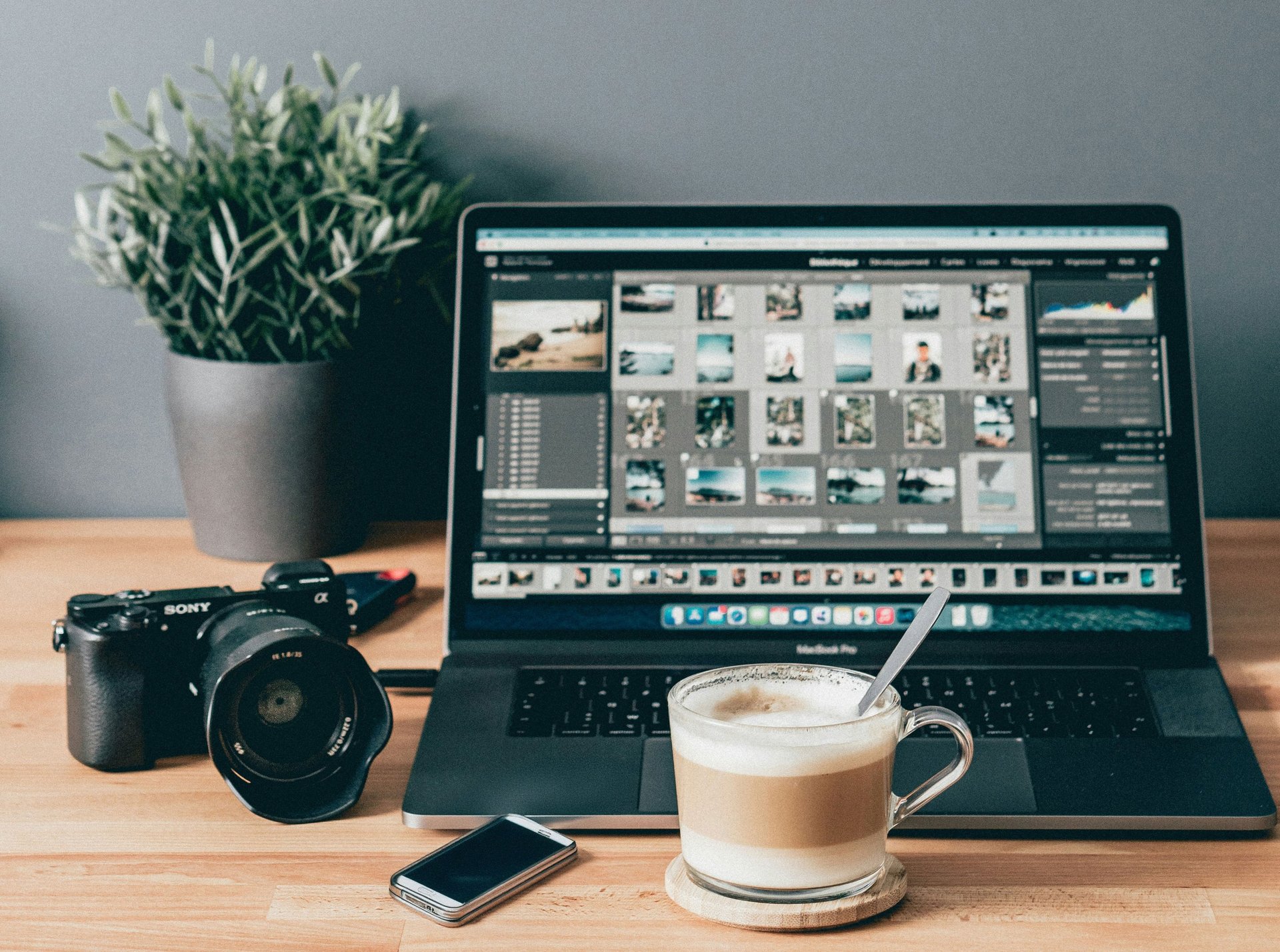 black laptop computer beside white ceramic mug on brown wooden table