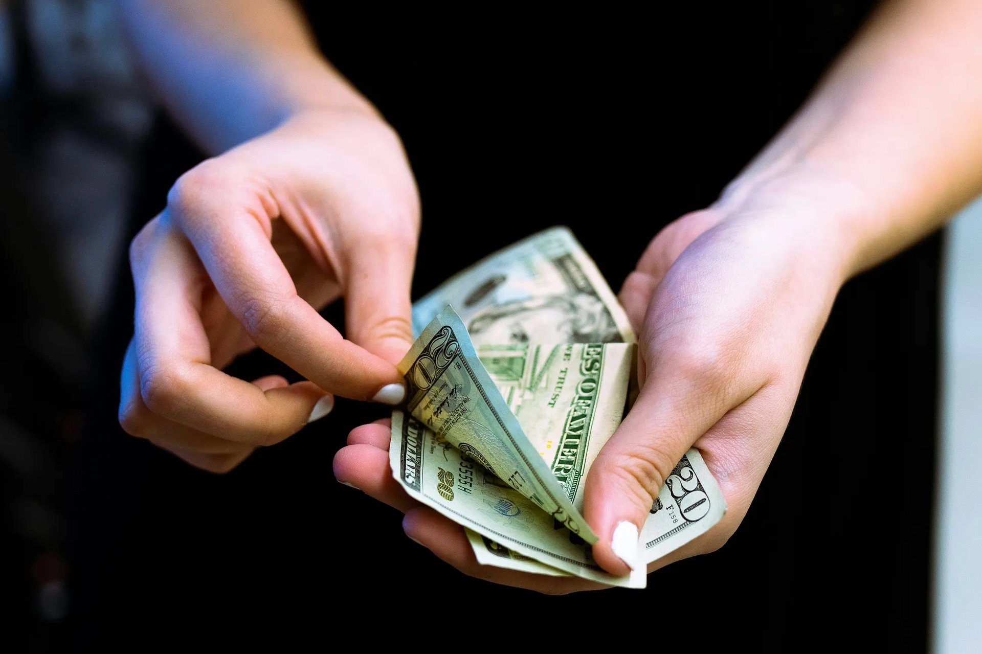 two hands touching each other in front of a pink background