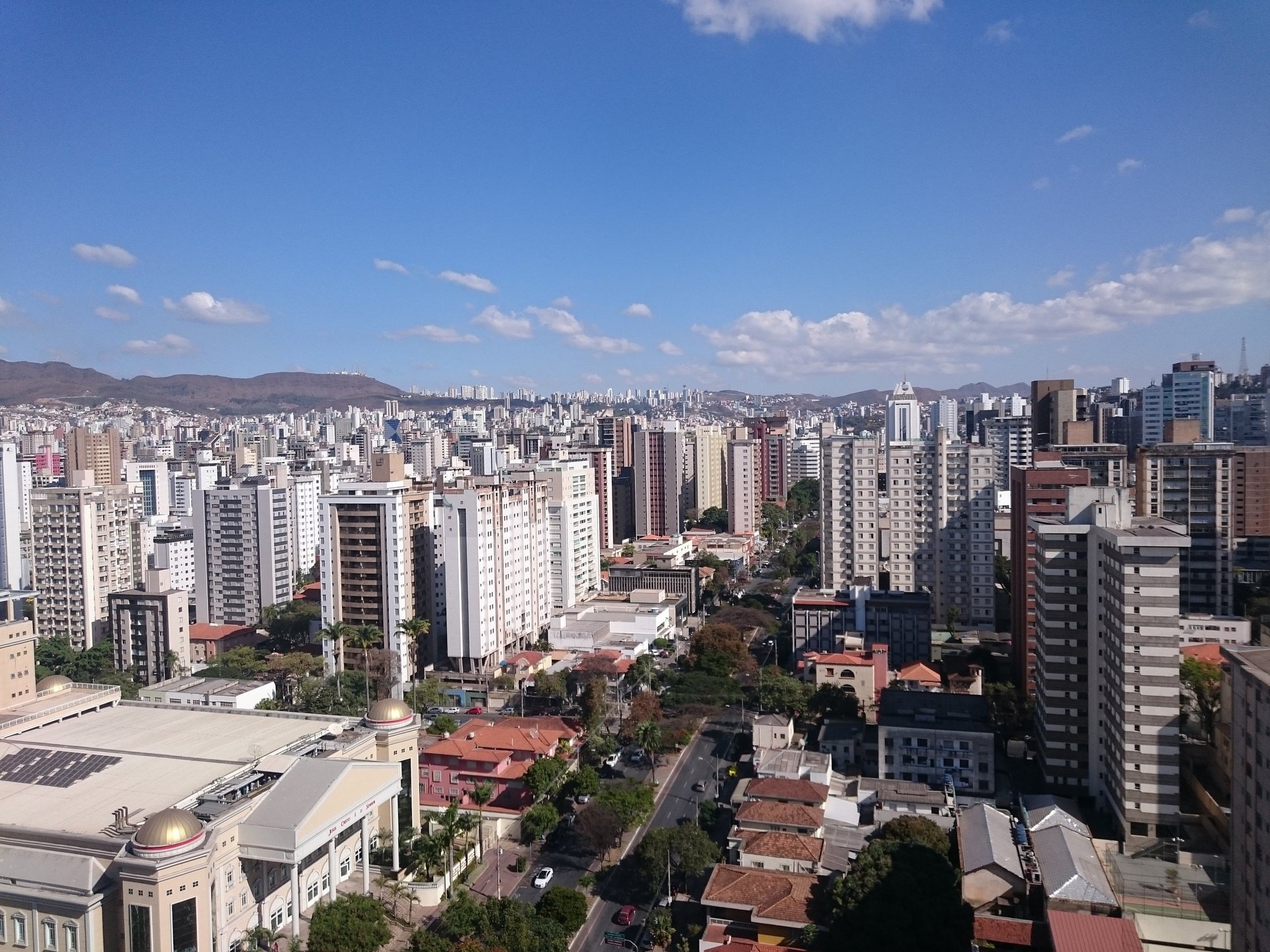 woman wearing yellow long-sleeved dress under white clouds and blue sky during daytime