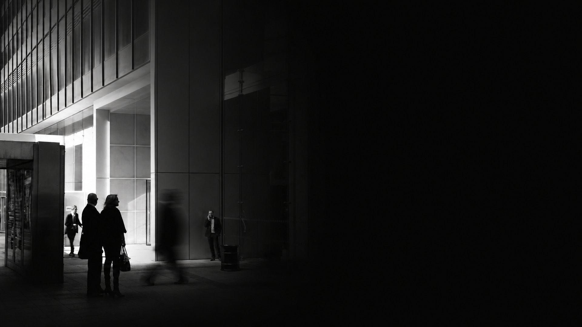 a black and white photo of a motorcycle parked in front of a building