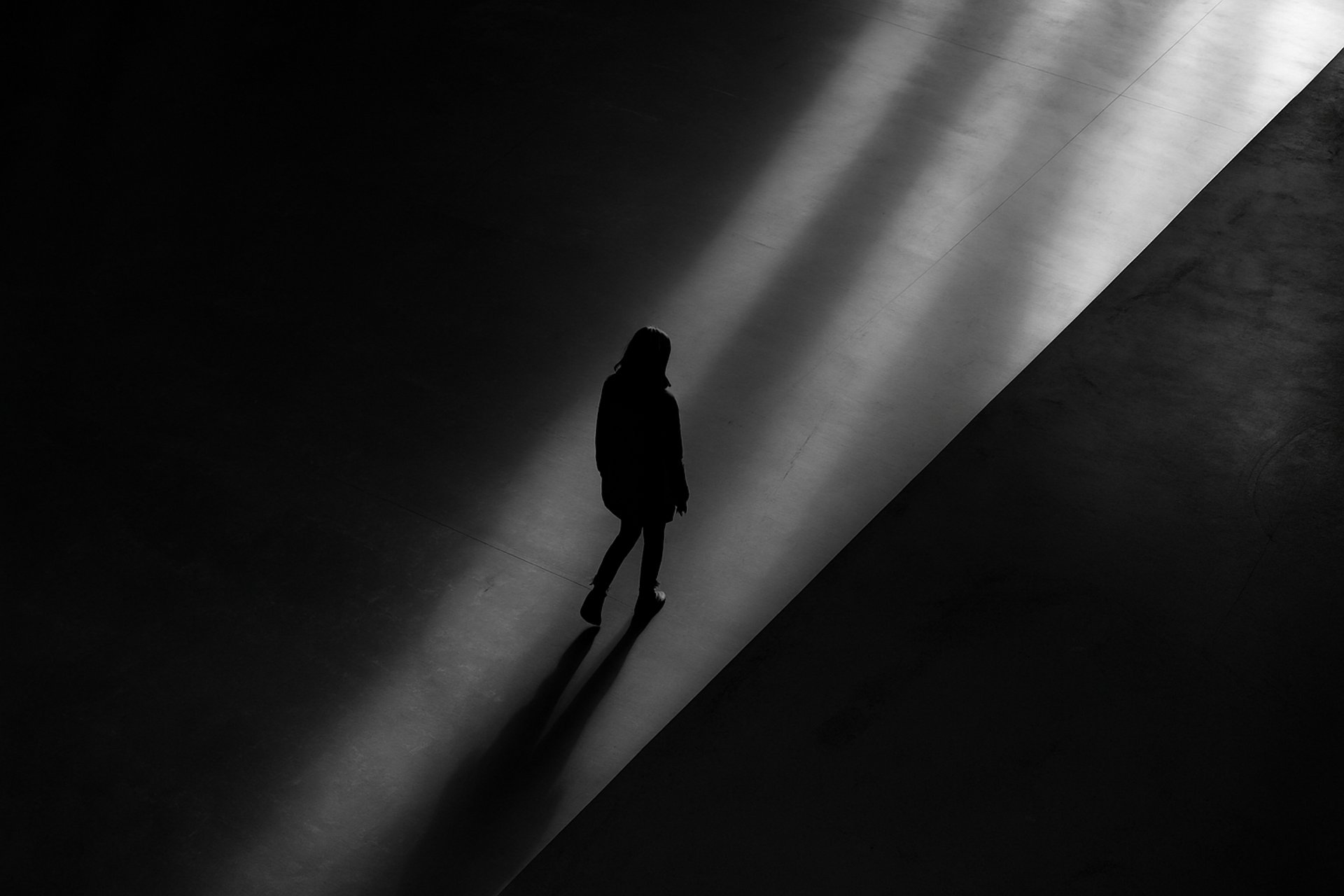 silhouette of man standing near wall on dark area
