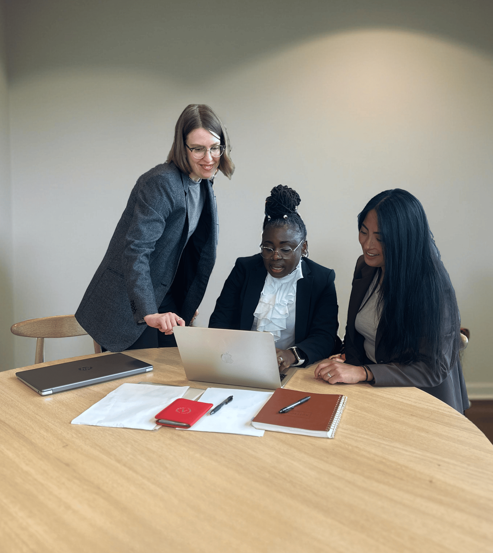a woman shaking hands with another woman sitting at a table