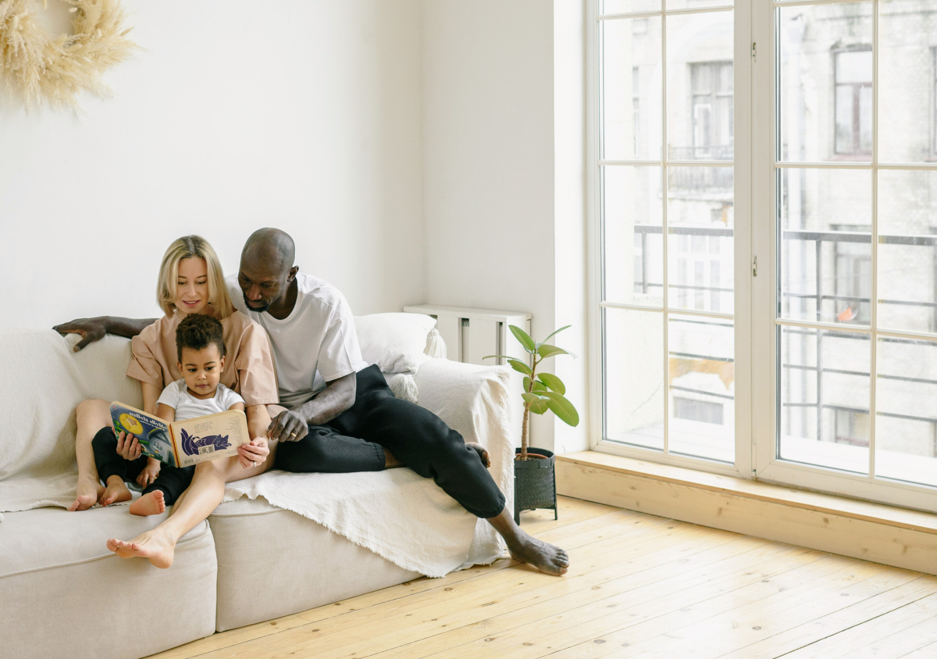 woman and baby sitting on white sofa