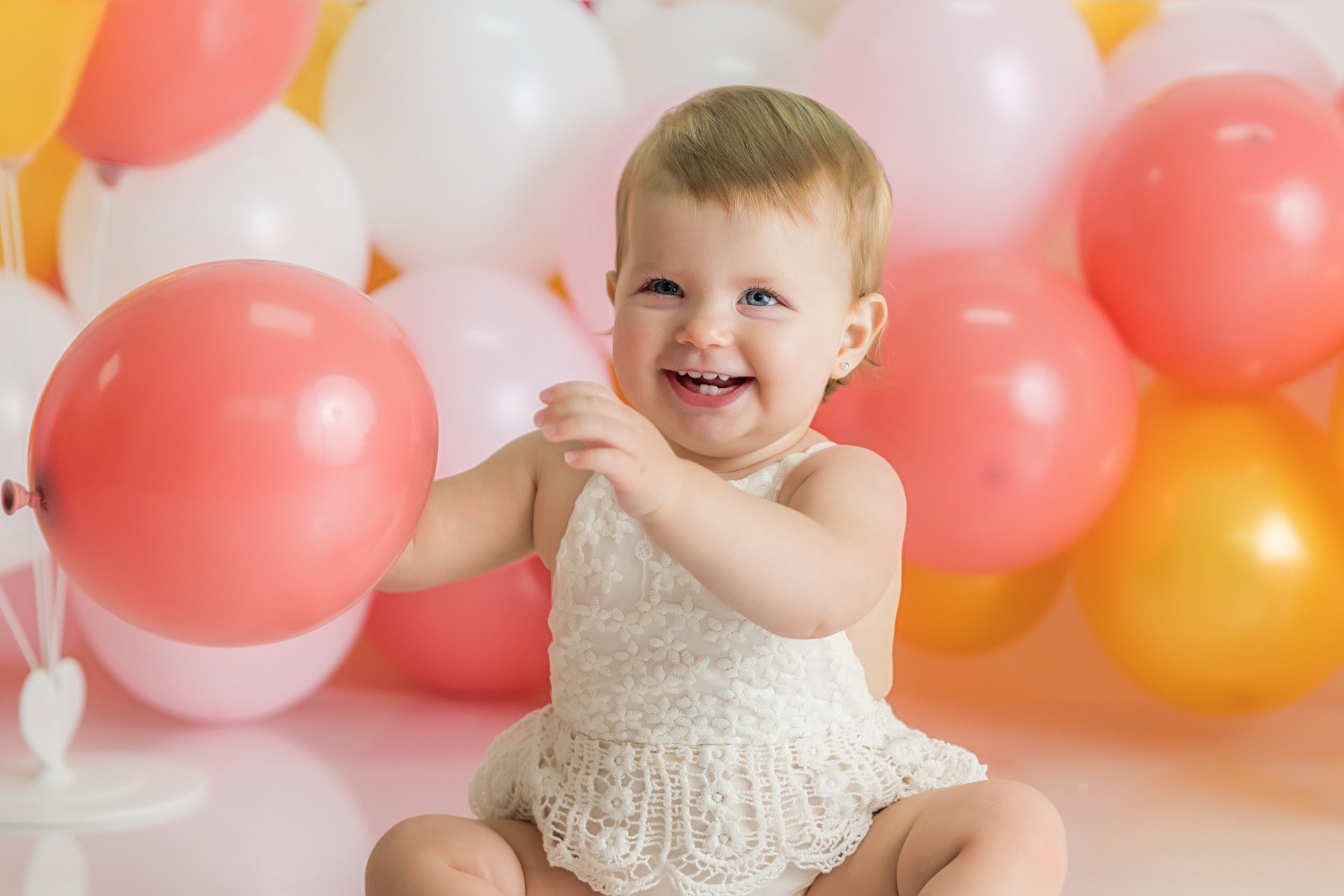 bebé cogiendo un globo durante sesión de smash cake