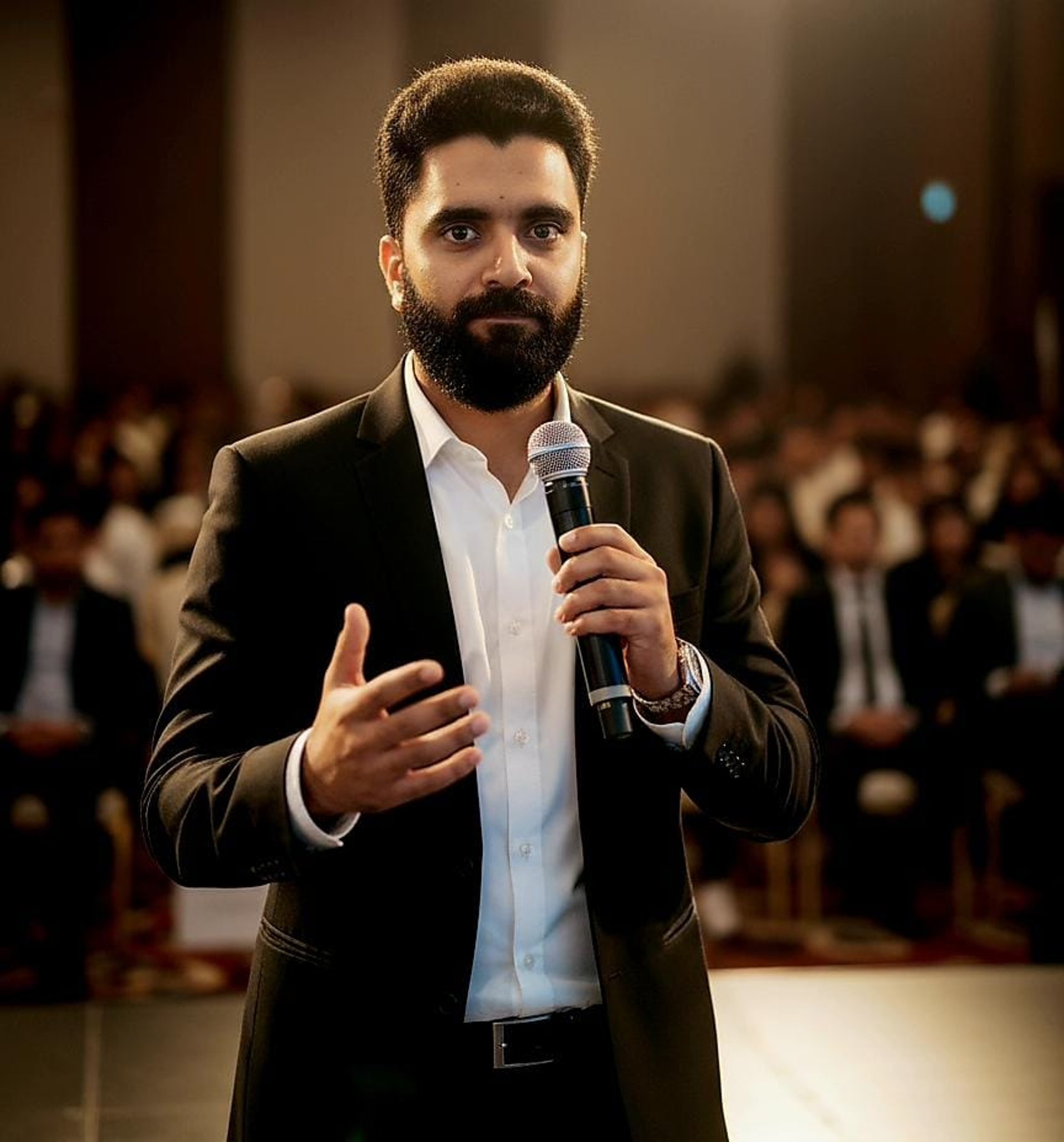 man in black suit standing near glass door