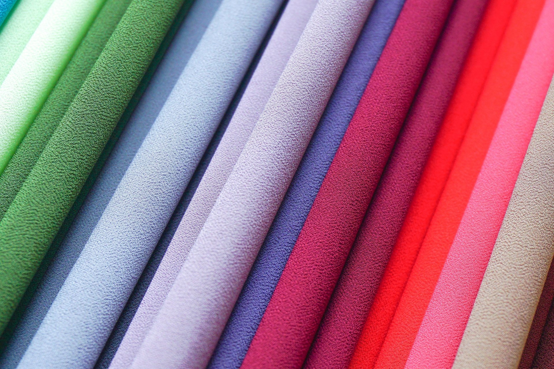 a pile of multicolored scarves sitting on top of a table