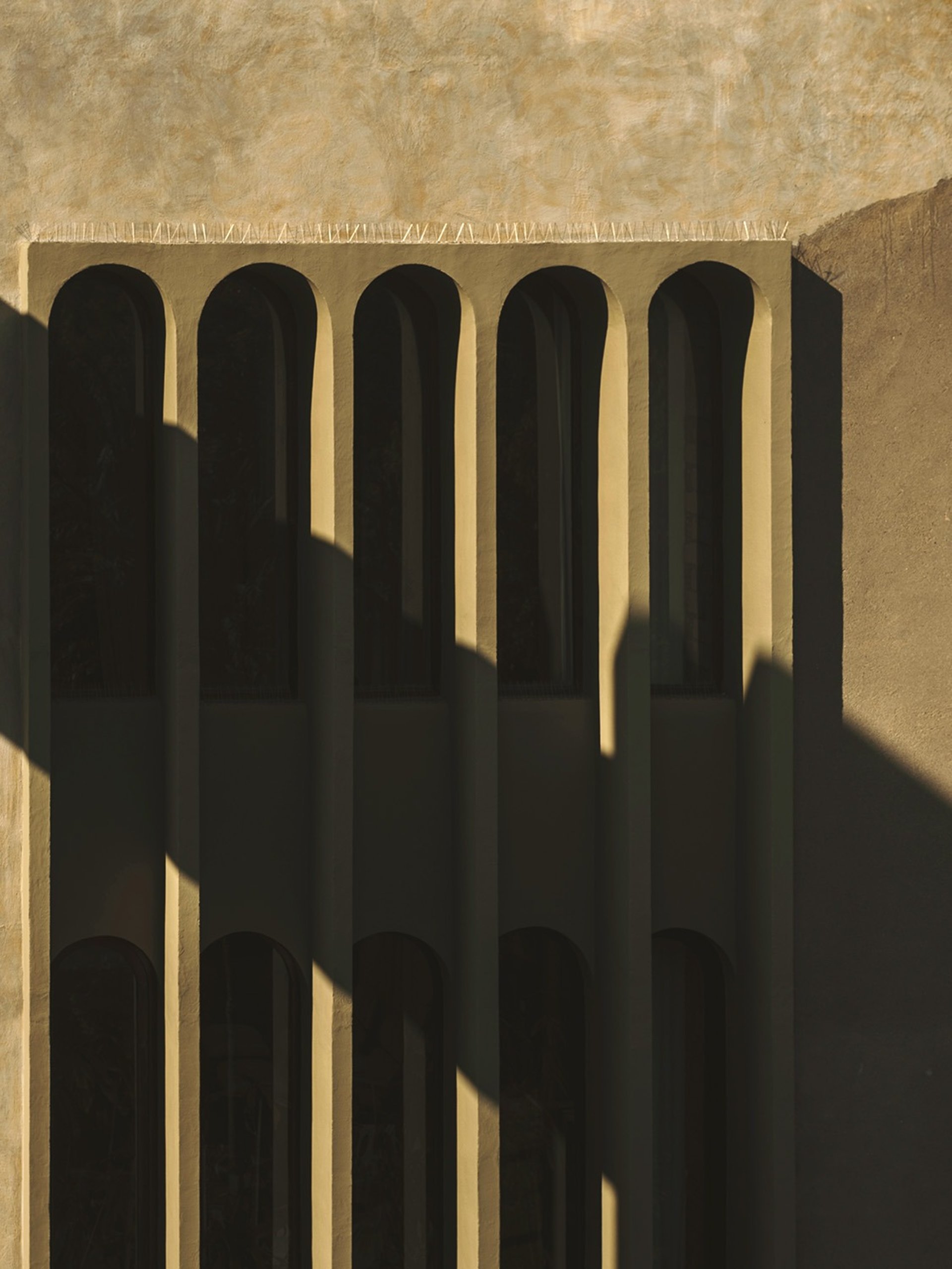an abstract photo of a curved building with a blue sky in the background