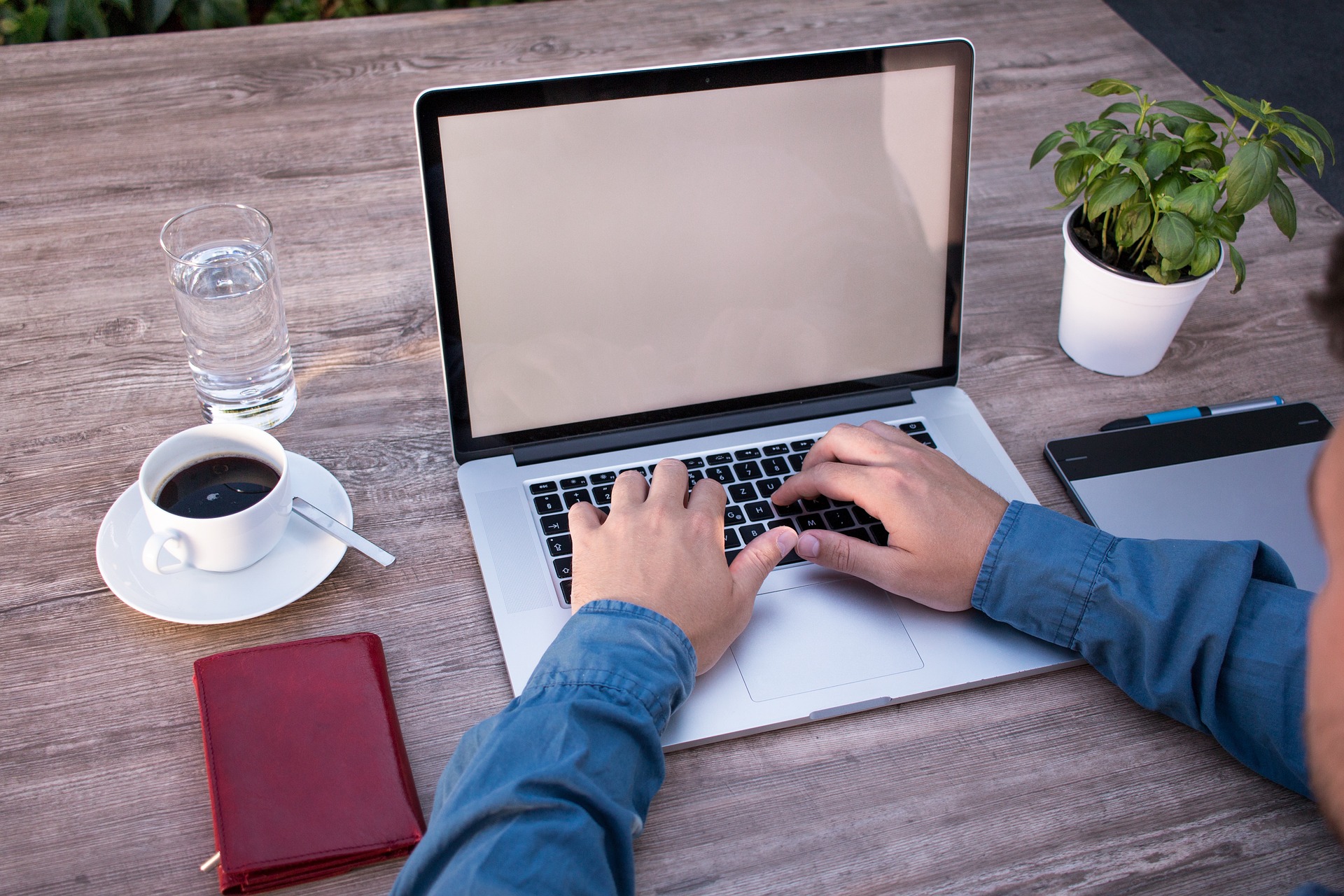 a woman sitting at a table working on a laptop